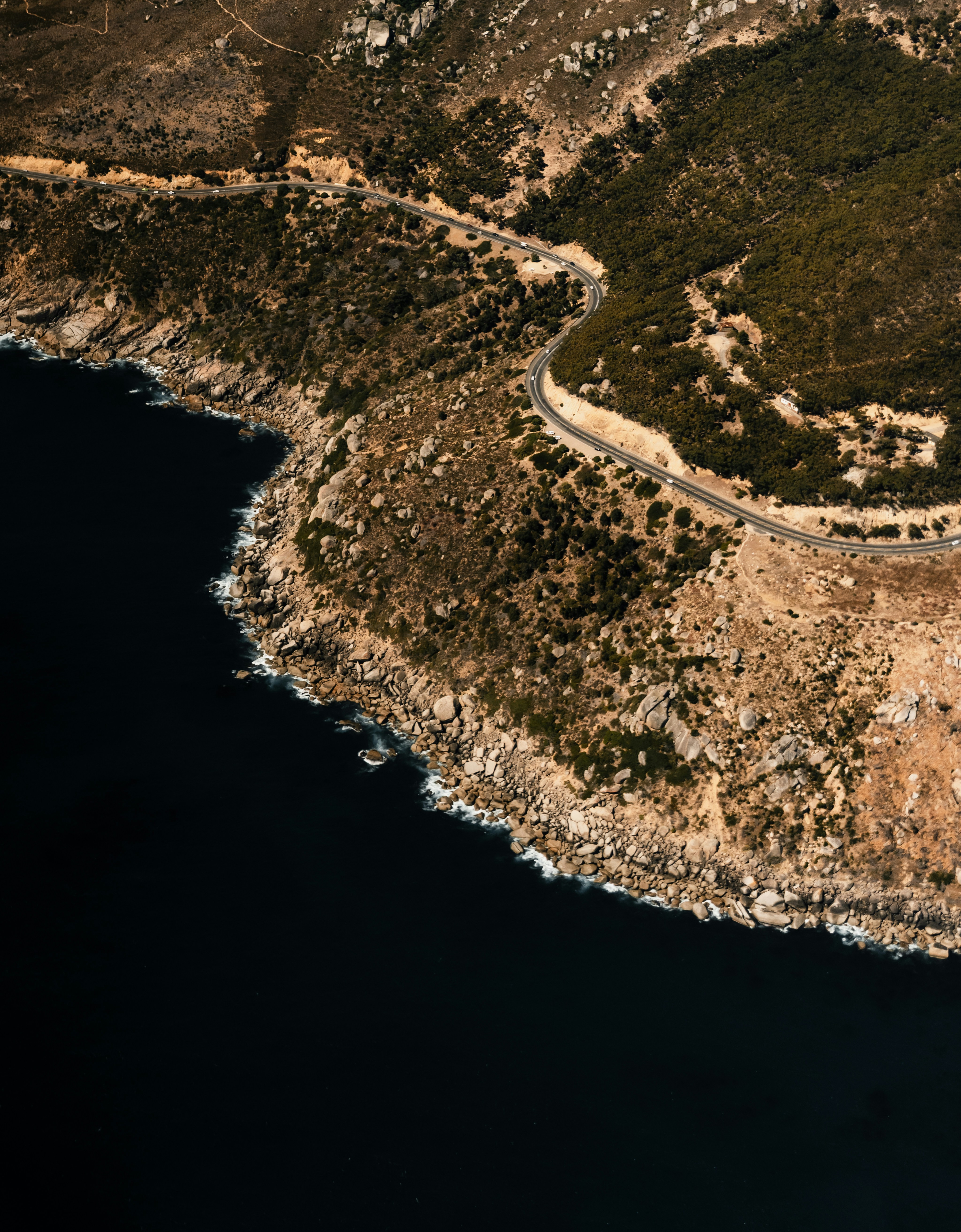 Carretera sinuosa a lo largo de una costa rocosa junto al oscuro océano