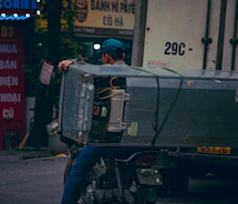 Man on motorcycle transports large appliance on truck