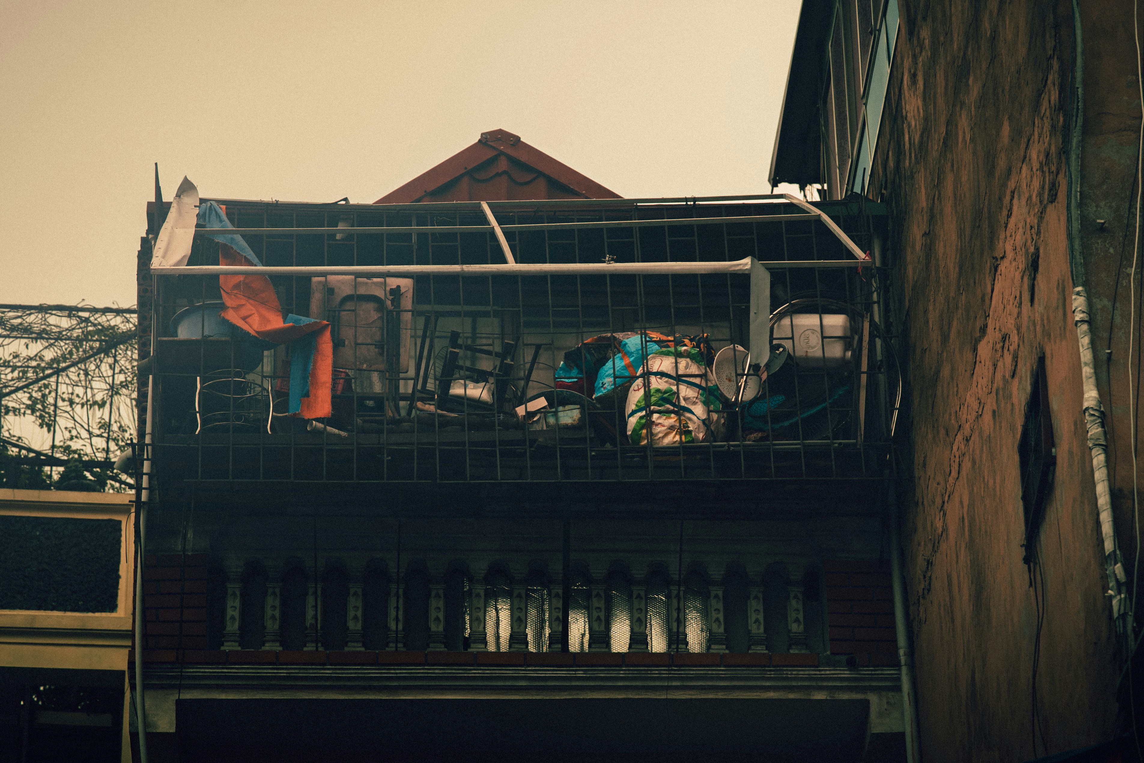Balcony with clothes and fan on old building