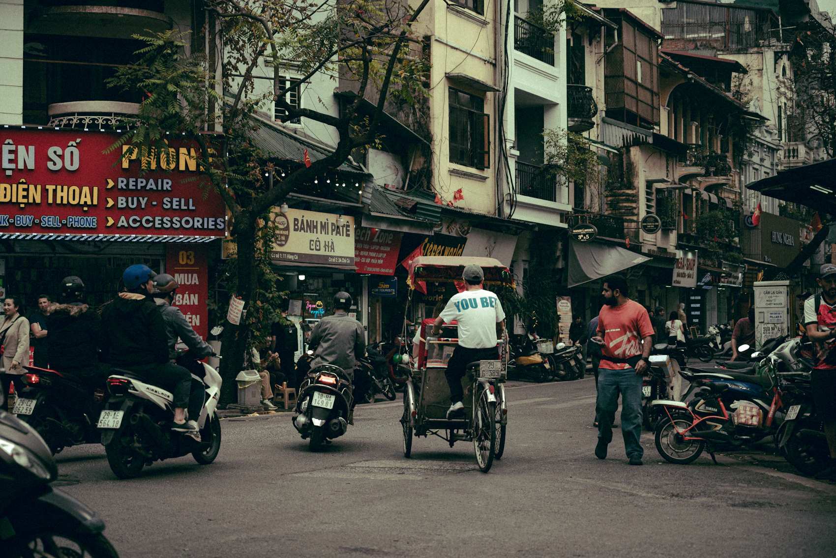 Motorbikes and pedestrians moving through Hanoi’s Old Quarter