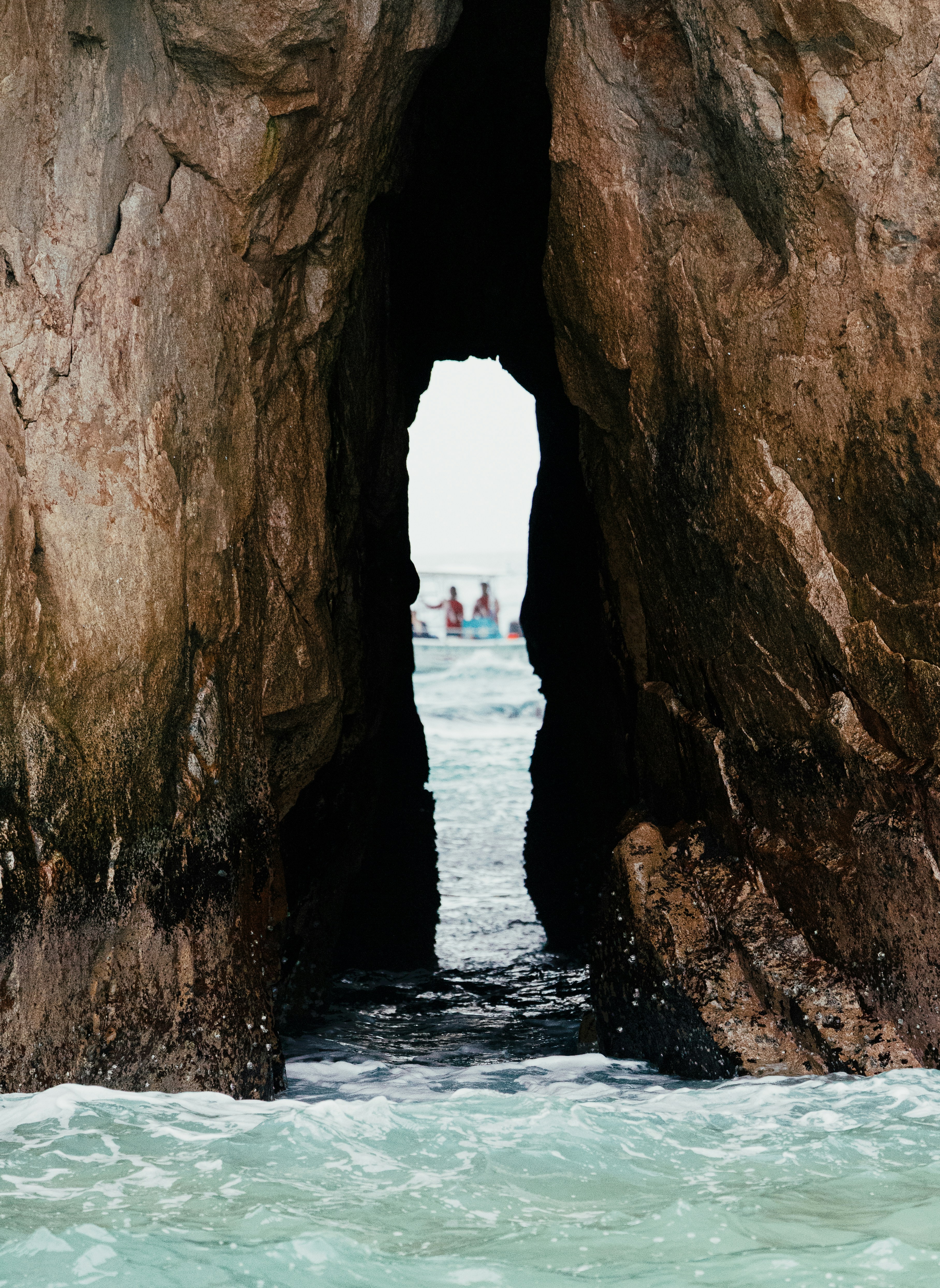 Seehöhle öffnet sich mit Menschen auf Booten in der Ferne