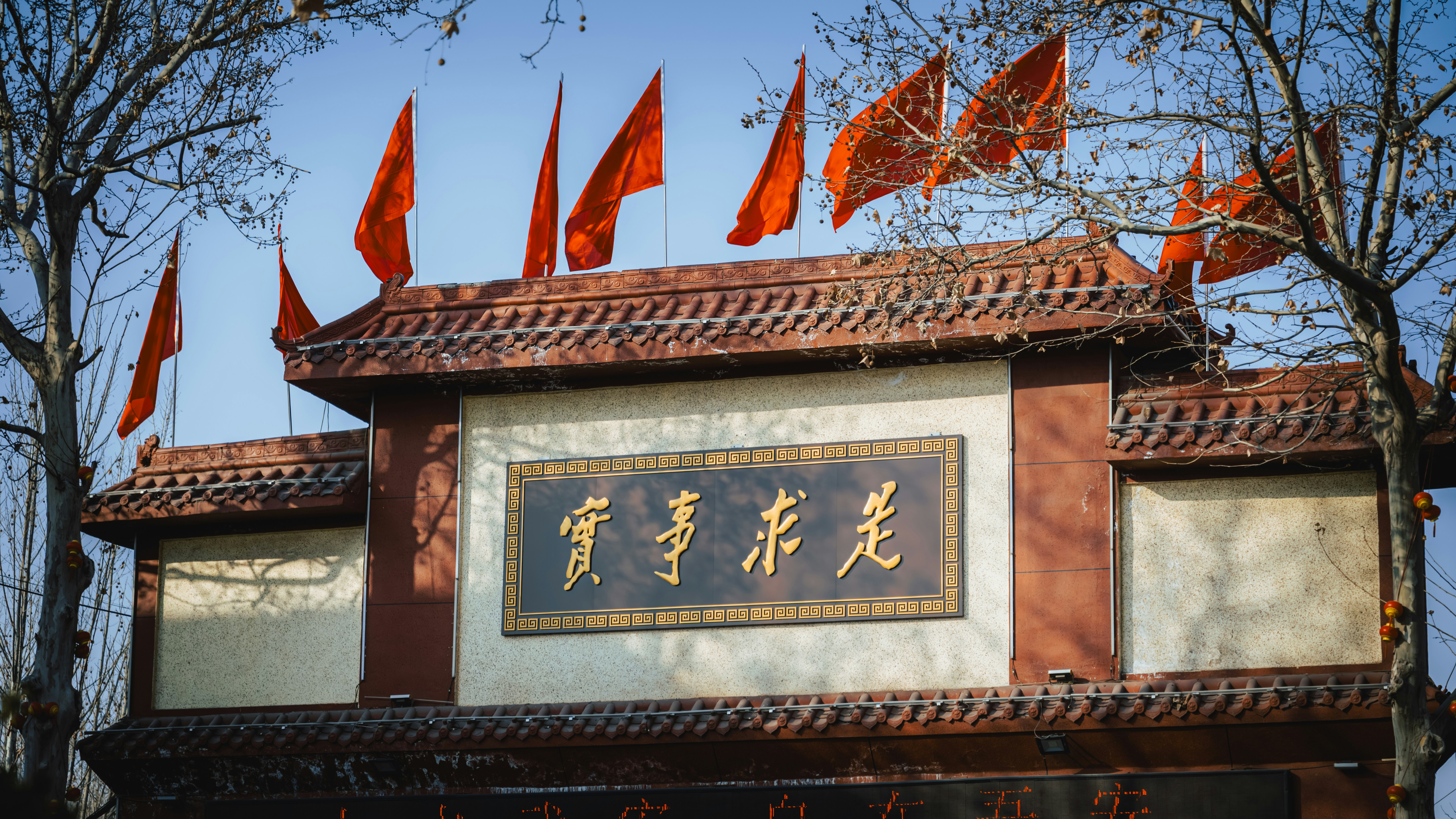 Ornate gate with red flags and chinese calligraphy