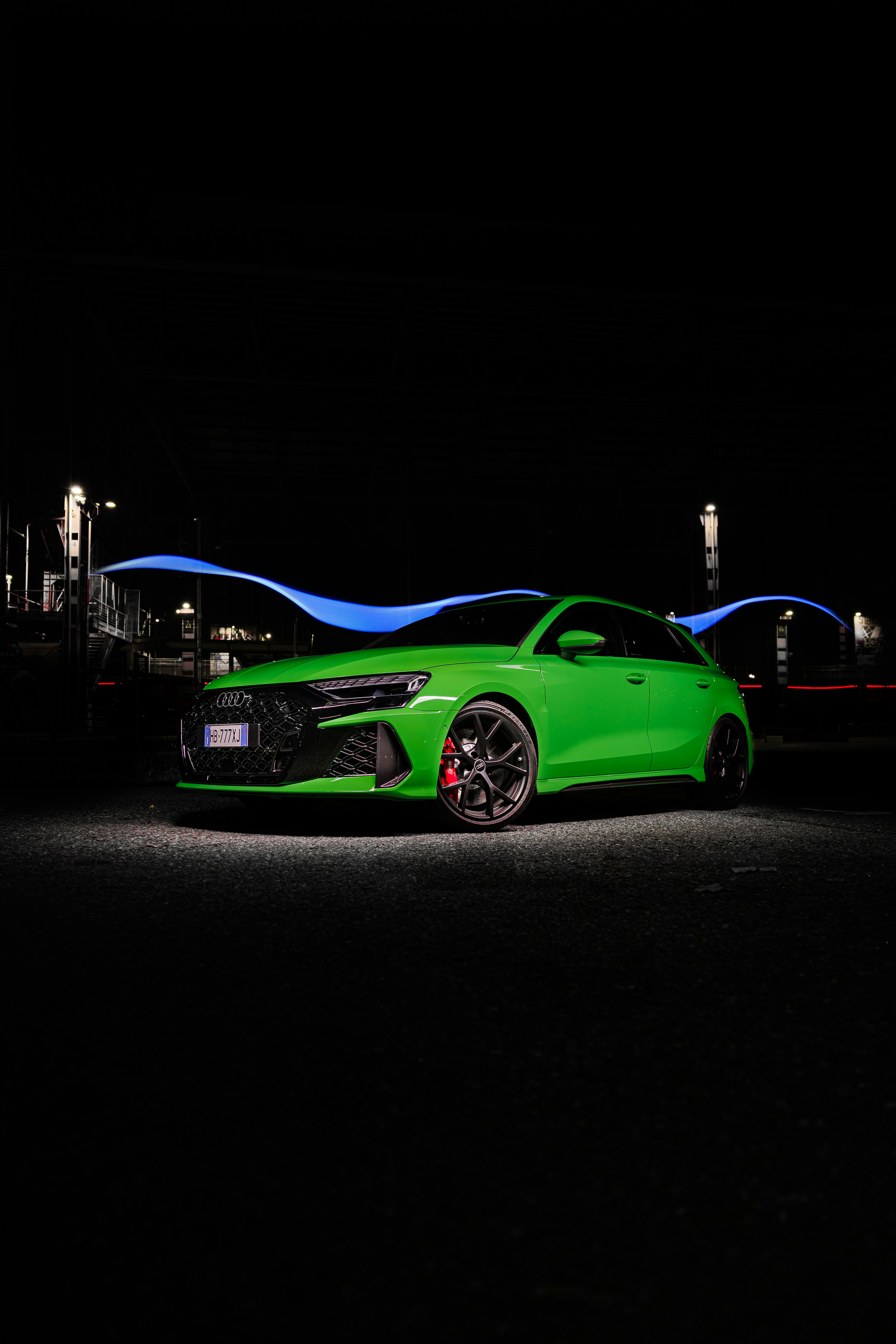 A bright green car parked at night