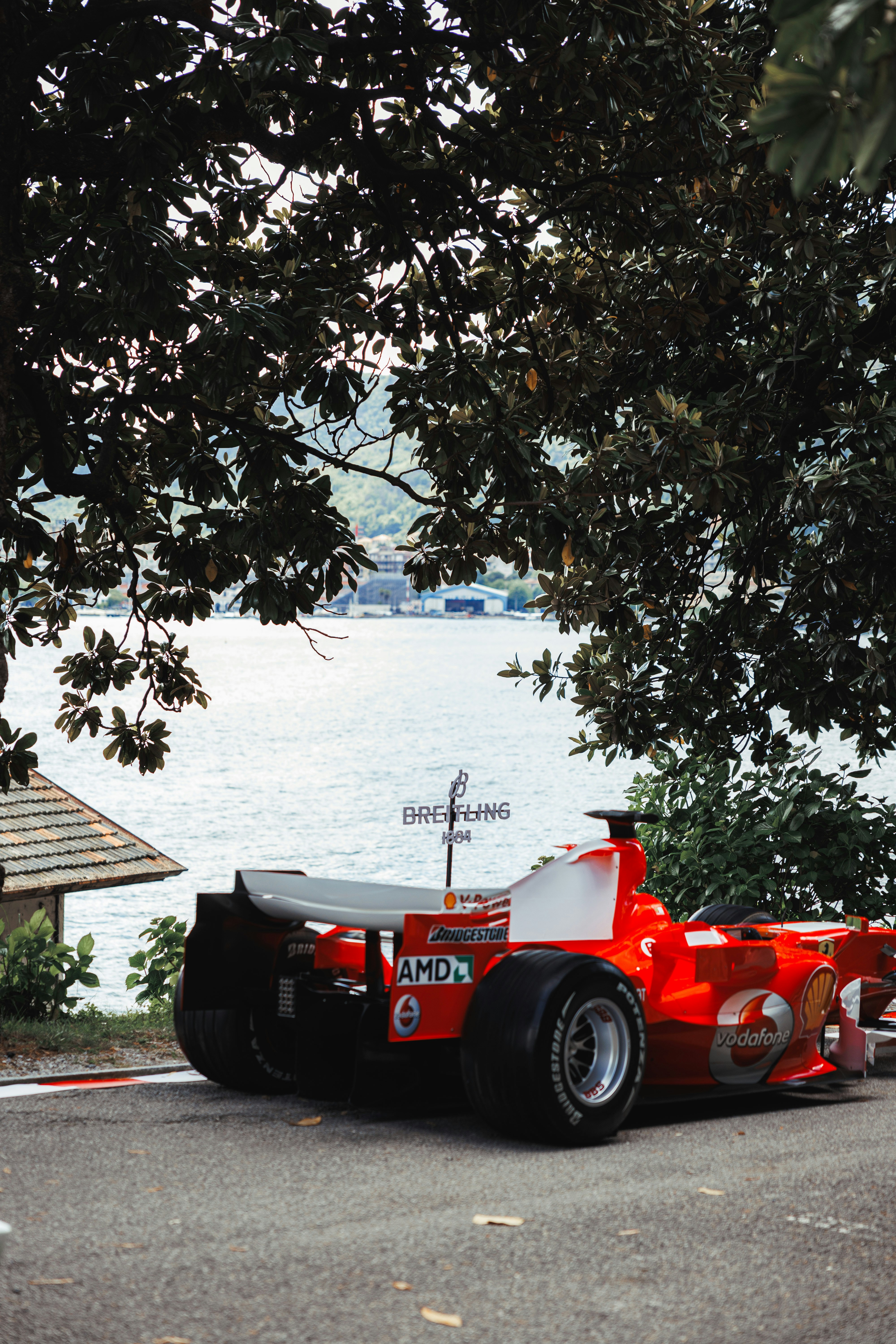 Red race car parked by the water