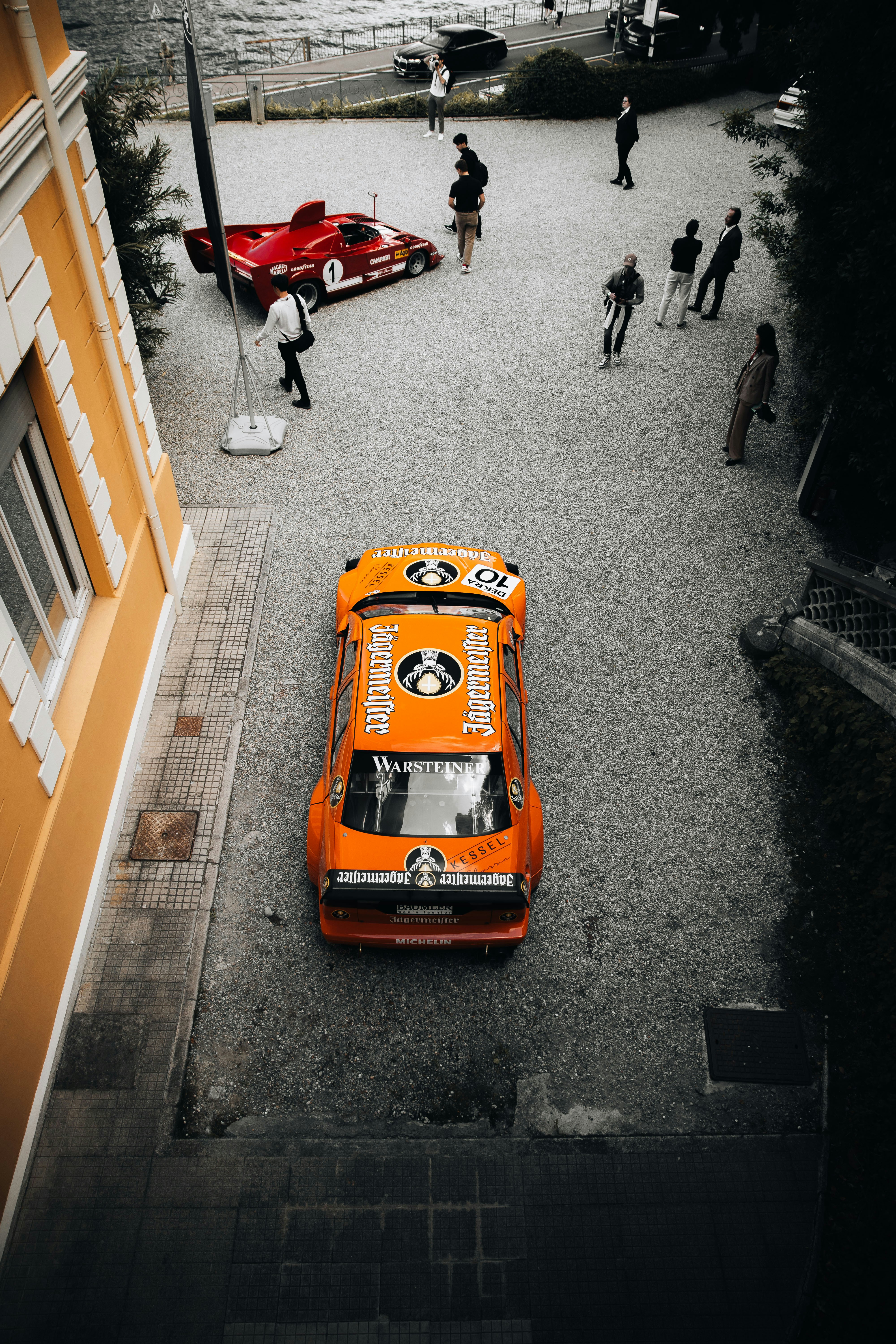 Orange vintage race car parked on gravel lot