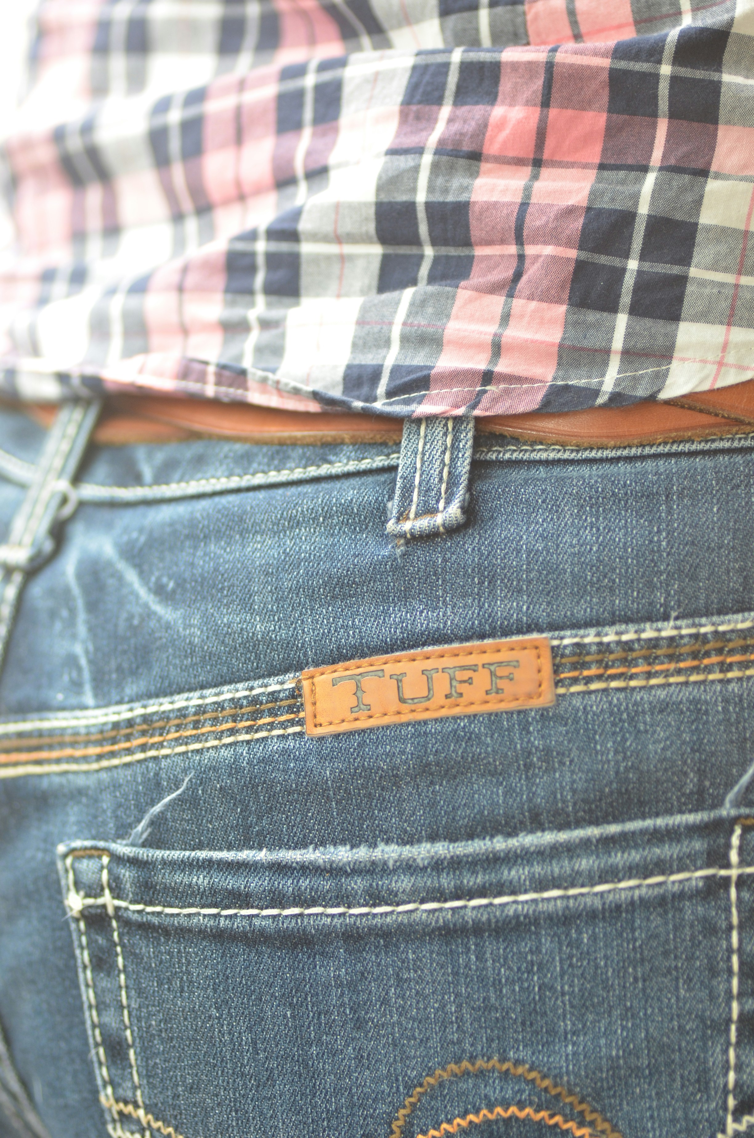 Close-up of blue jeans with a leather patch.