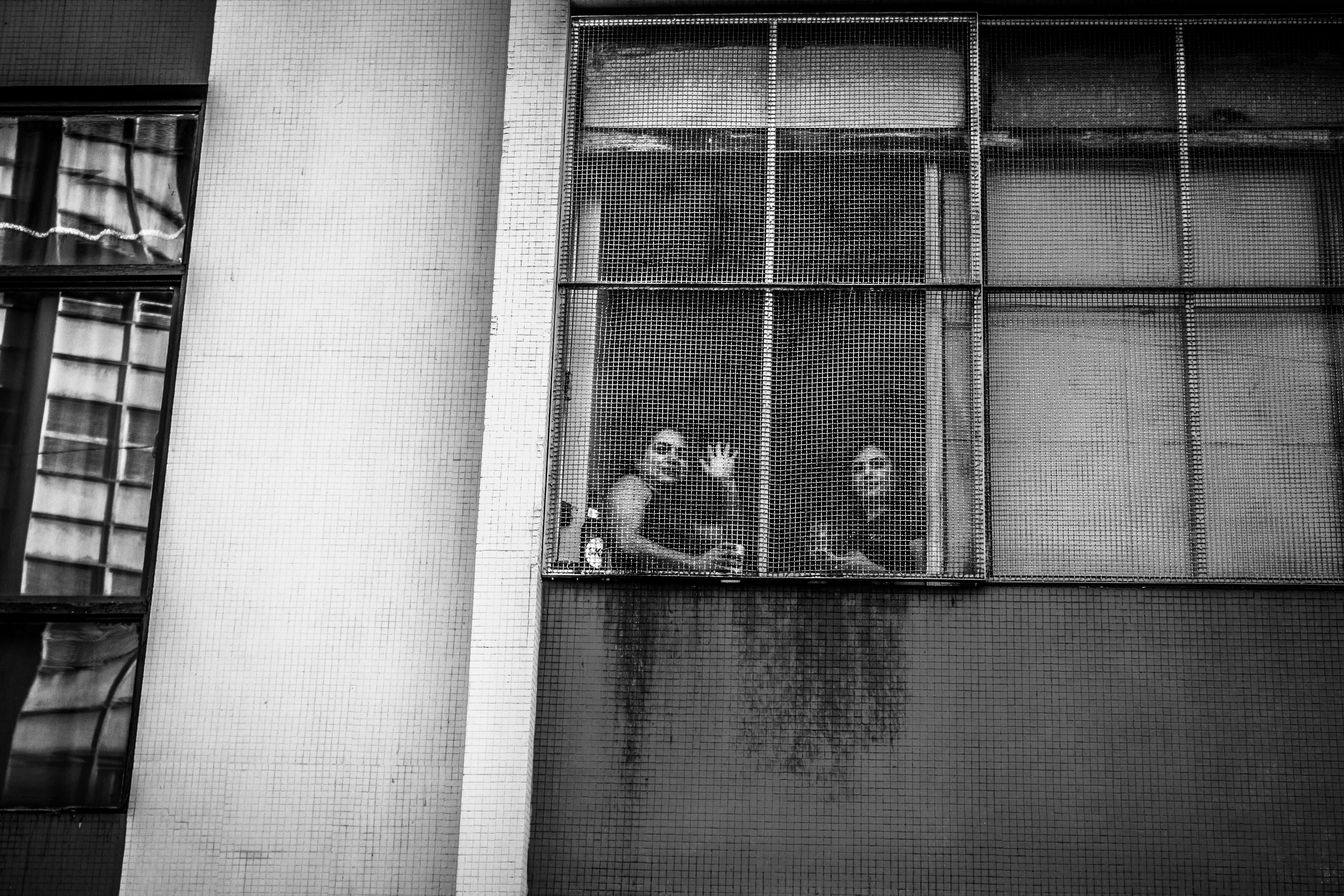 Two people look out a grimy window