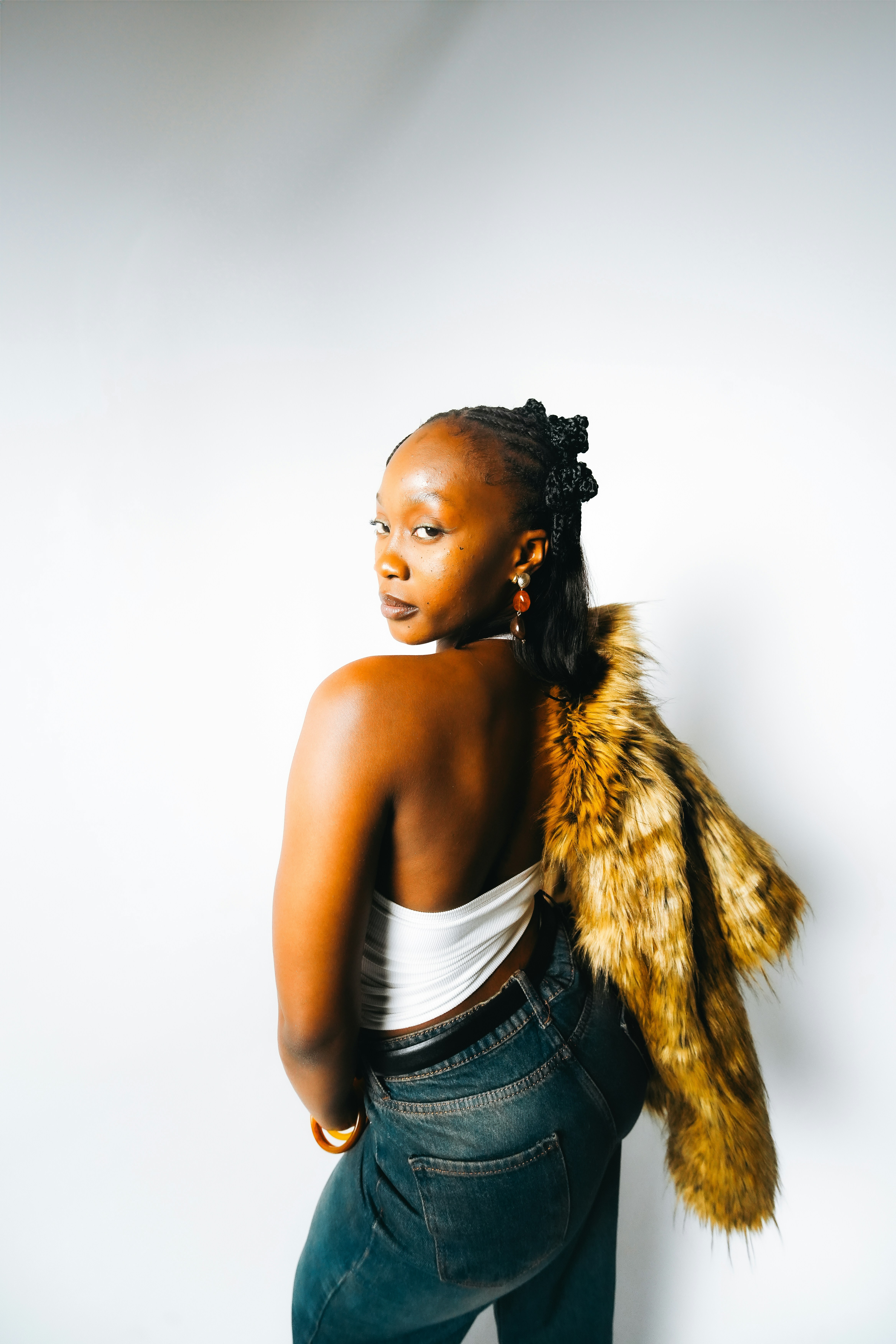 Young woman in fur coat and jeans