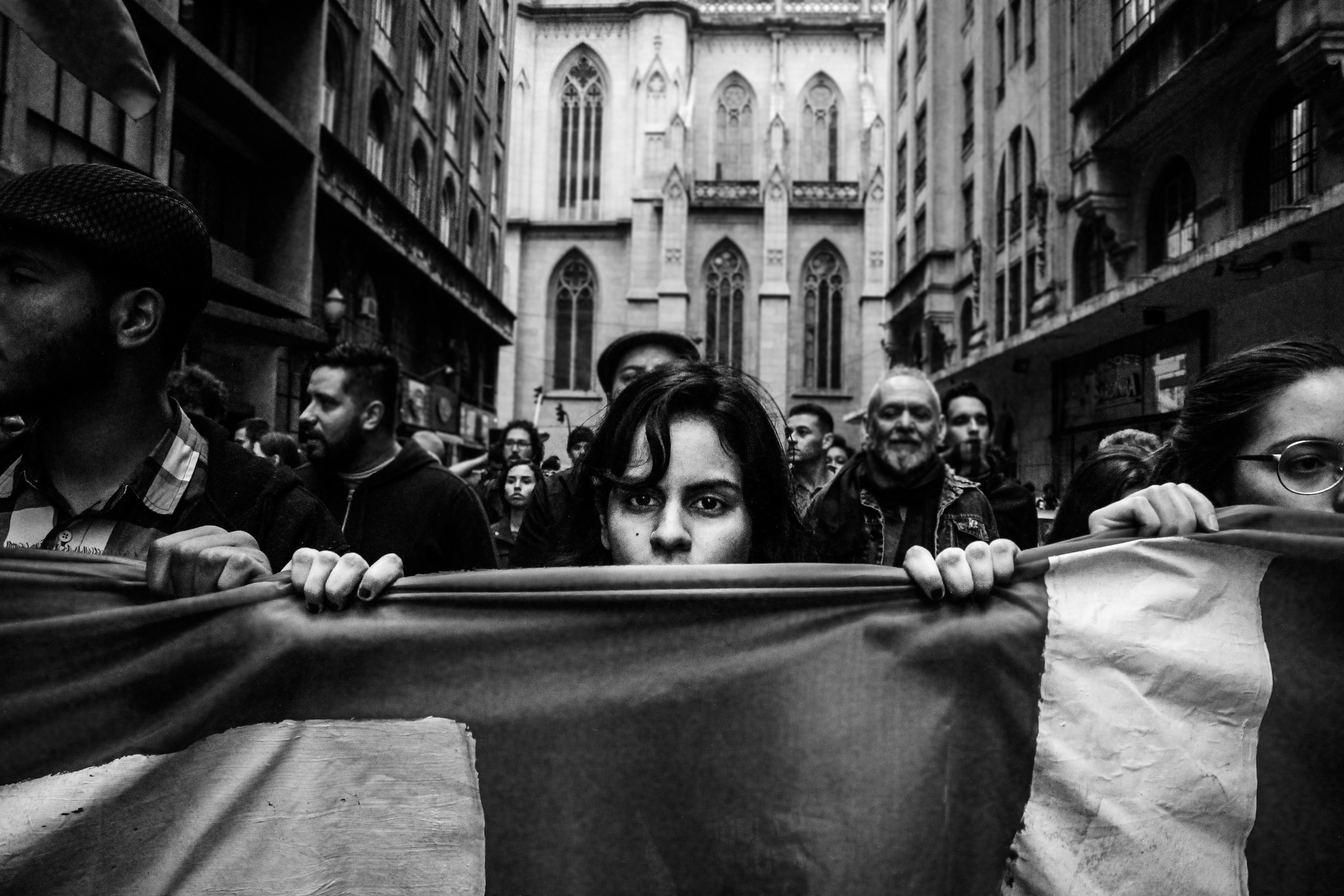 Una donna sbircia oltre uno striscione durante una protesta