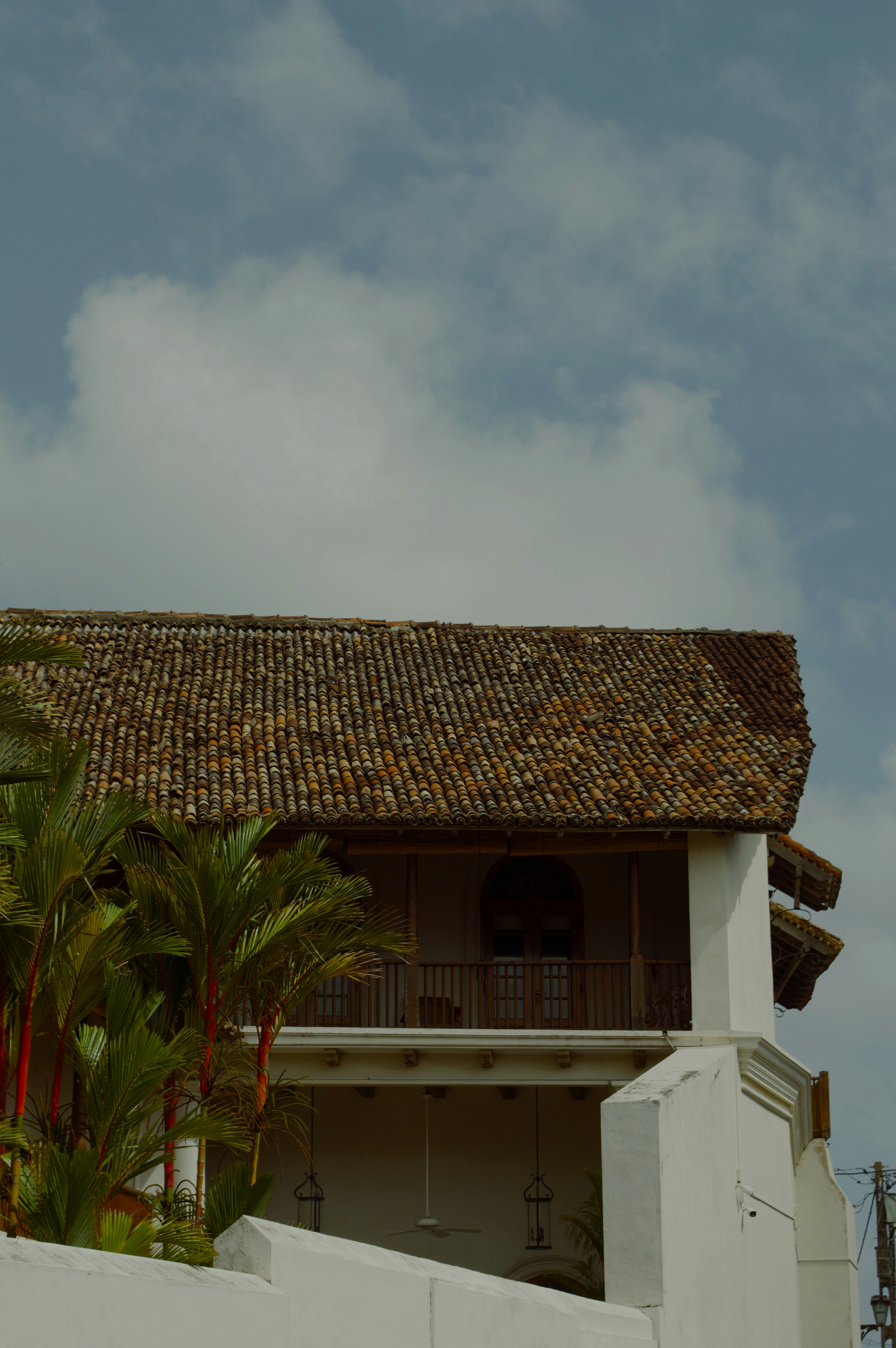 Edificio blanco con tejas y palmeras