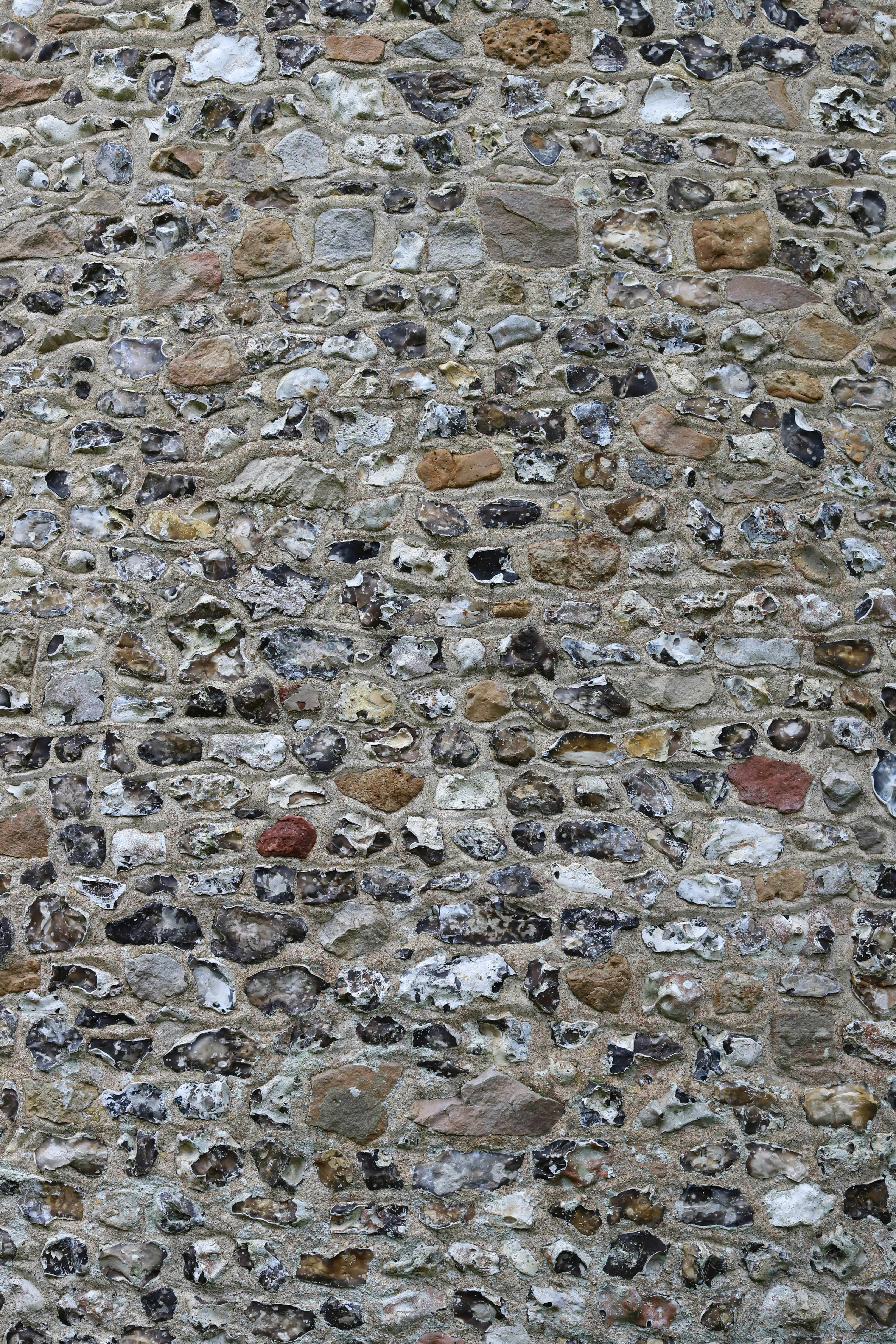 A textured wall made of rough stones and mortar.