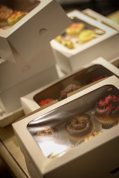 Several boxes of assorted cupcakes on a table.