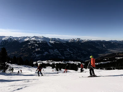 People skiing down a snowy mountain slope