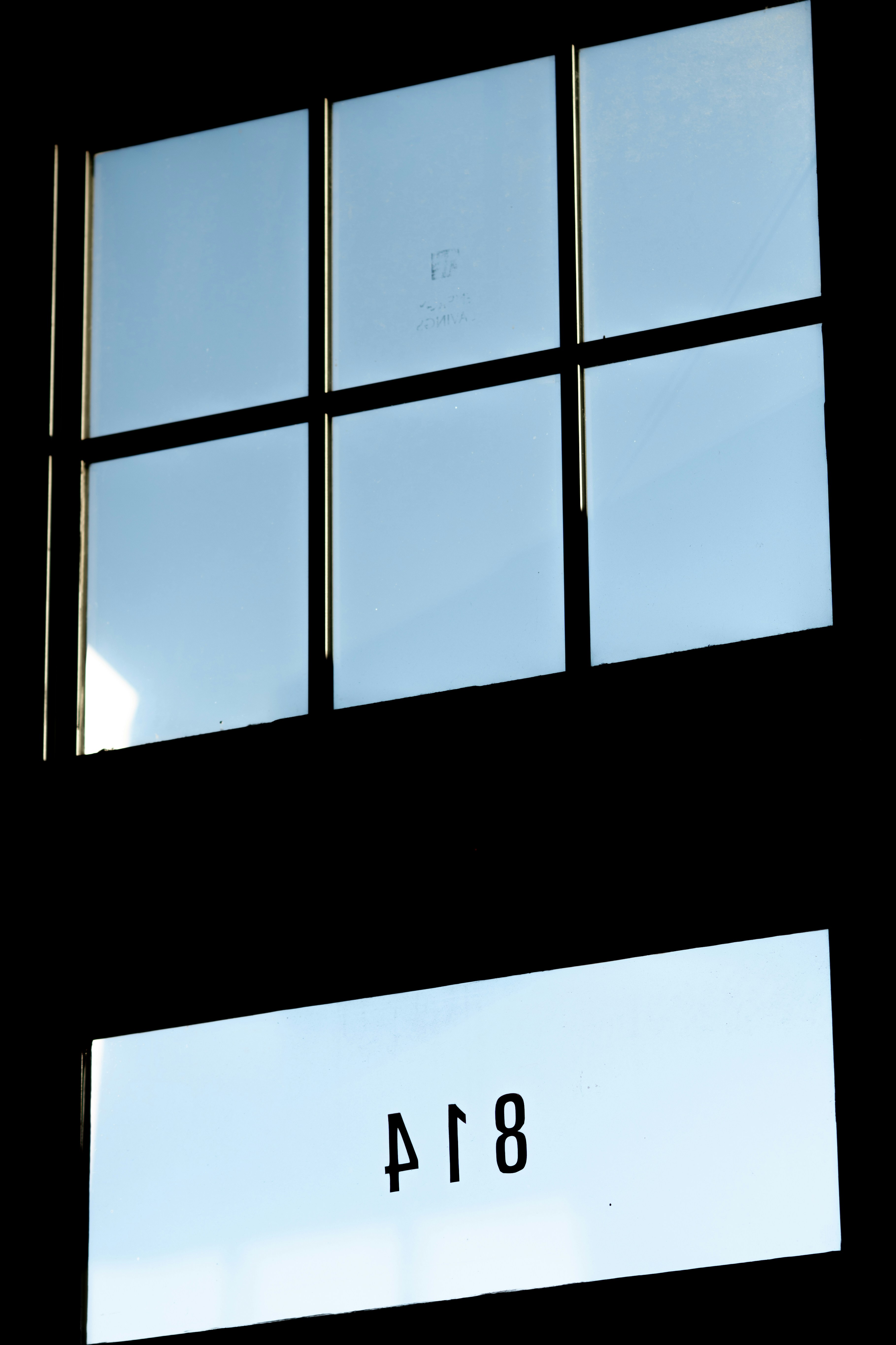 A window with a sky reflection and the number 814.
