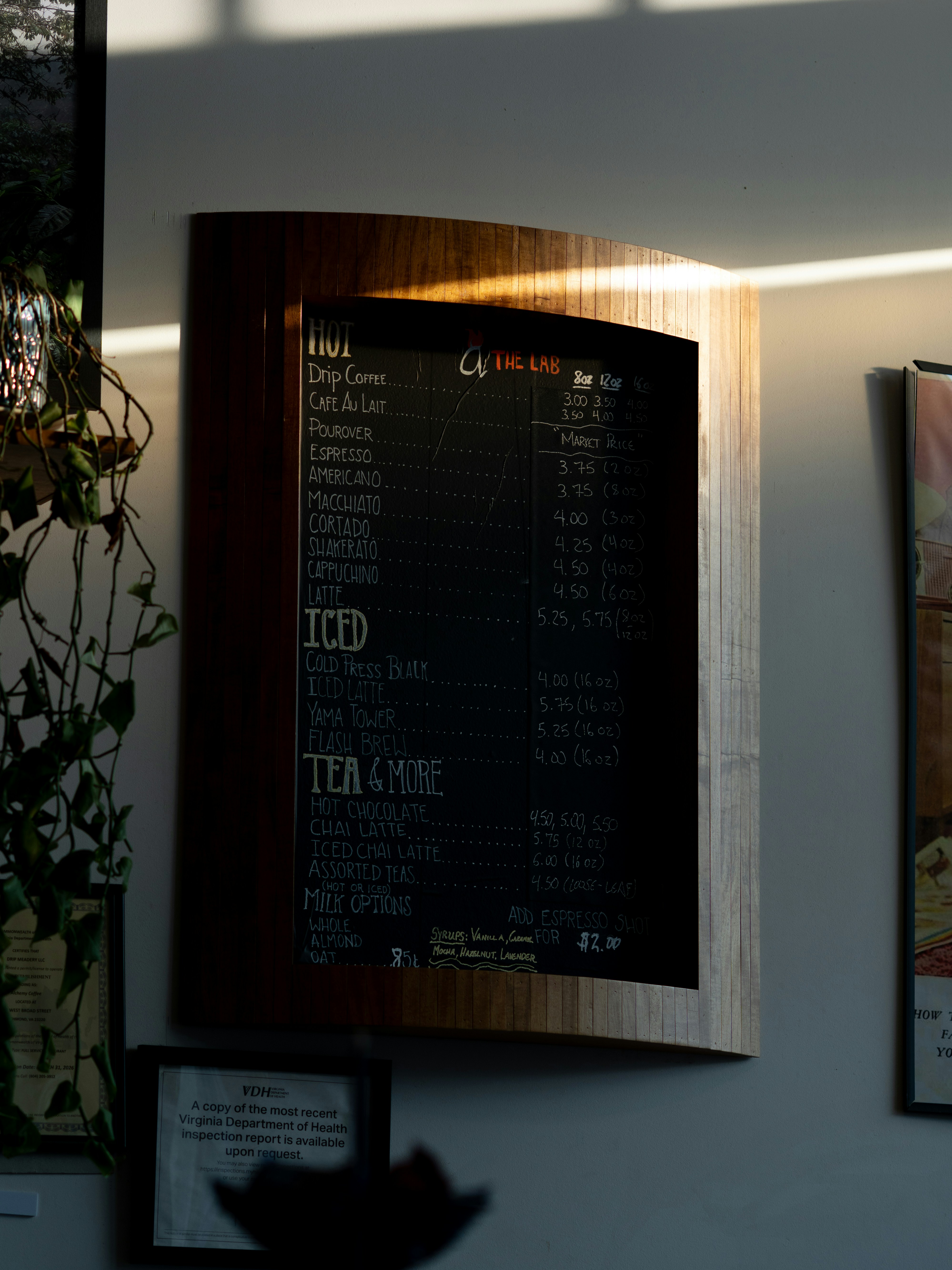 A coffee shop menu board hangs on a wall.