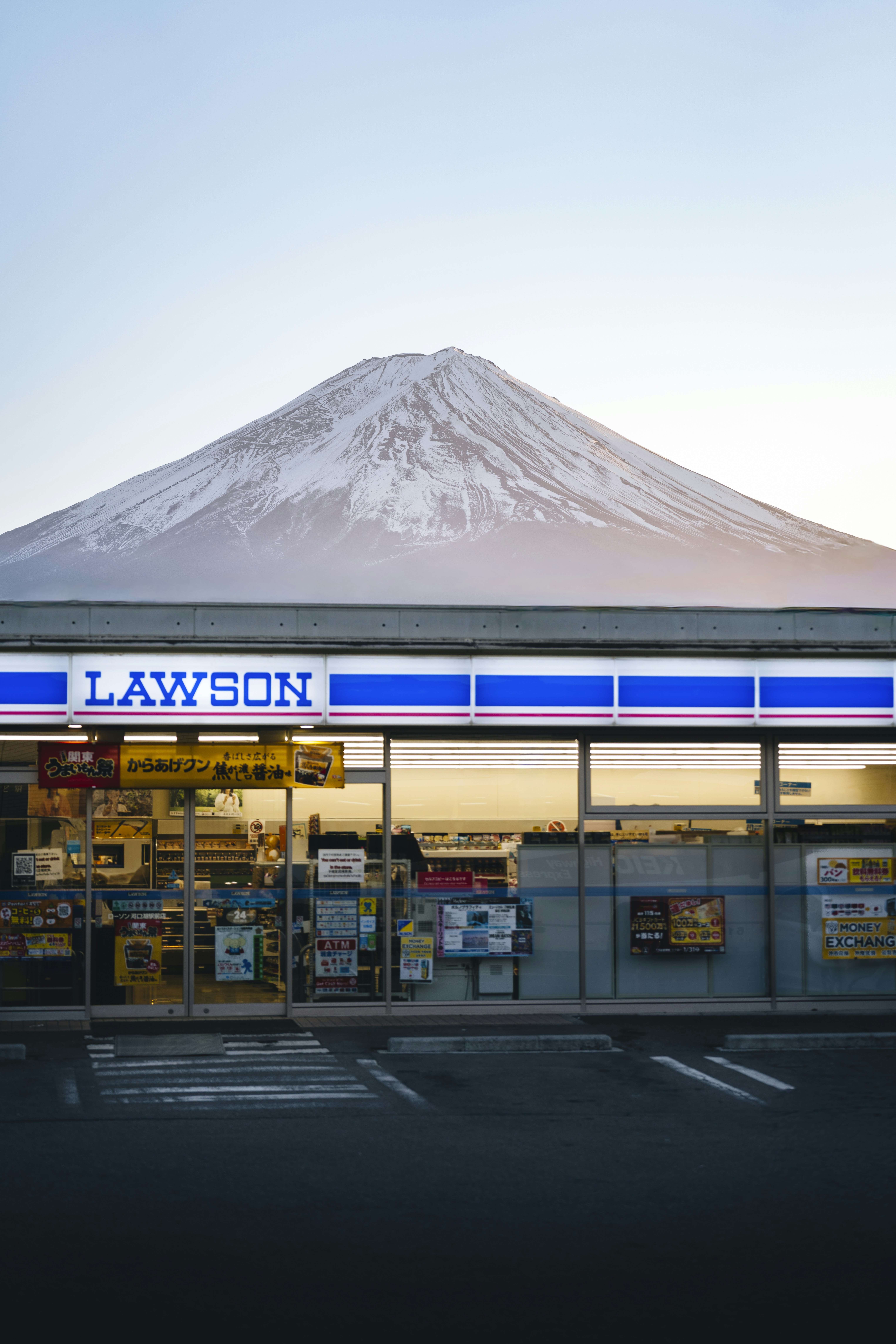 Mount fuji looms over a lawson convenience store.