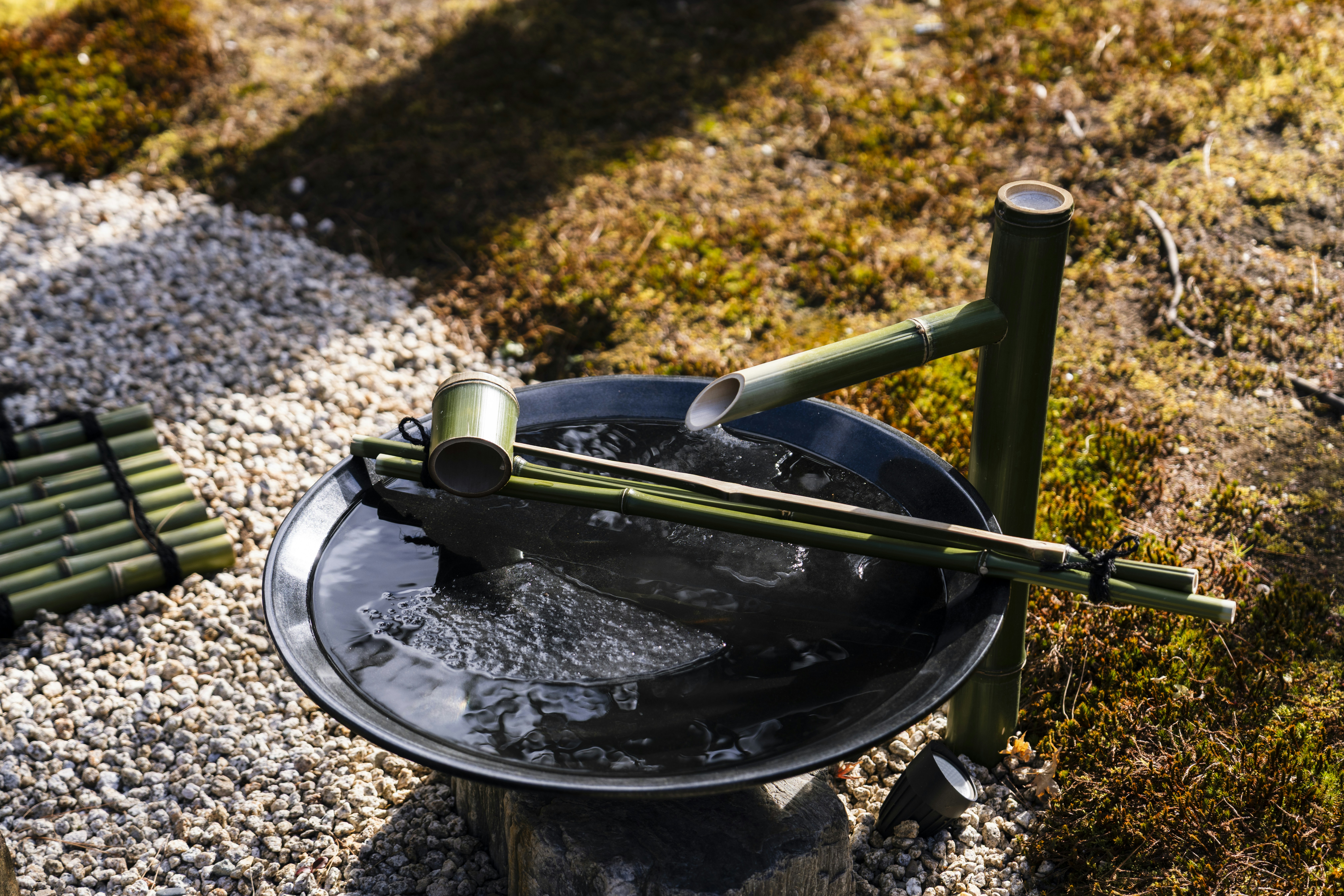 Bamboo water feature with flowing water in a garden