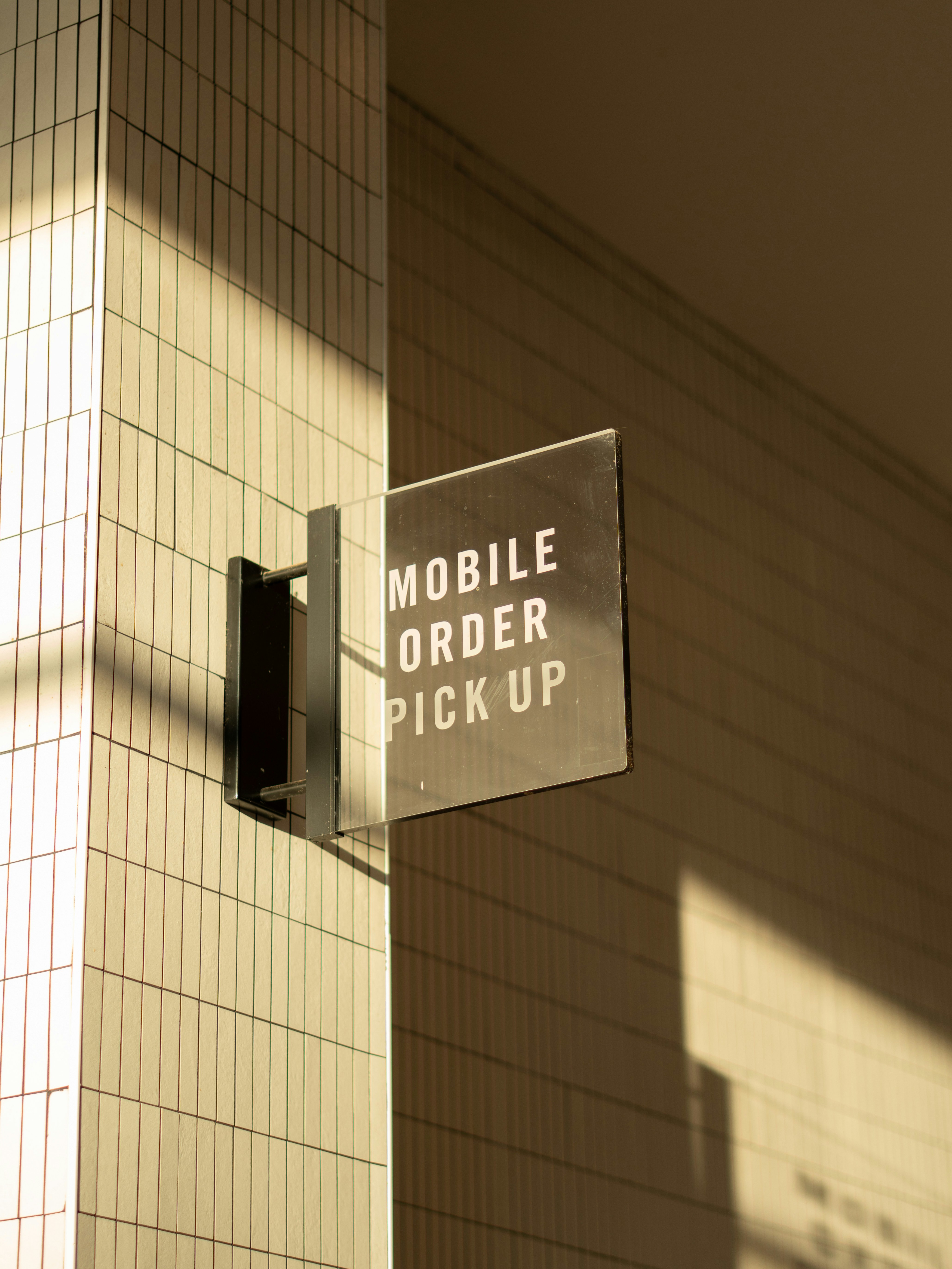Firma para recogida de pedidos móviles en una pared de azulejos.