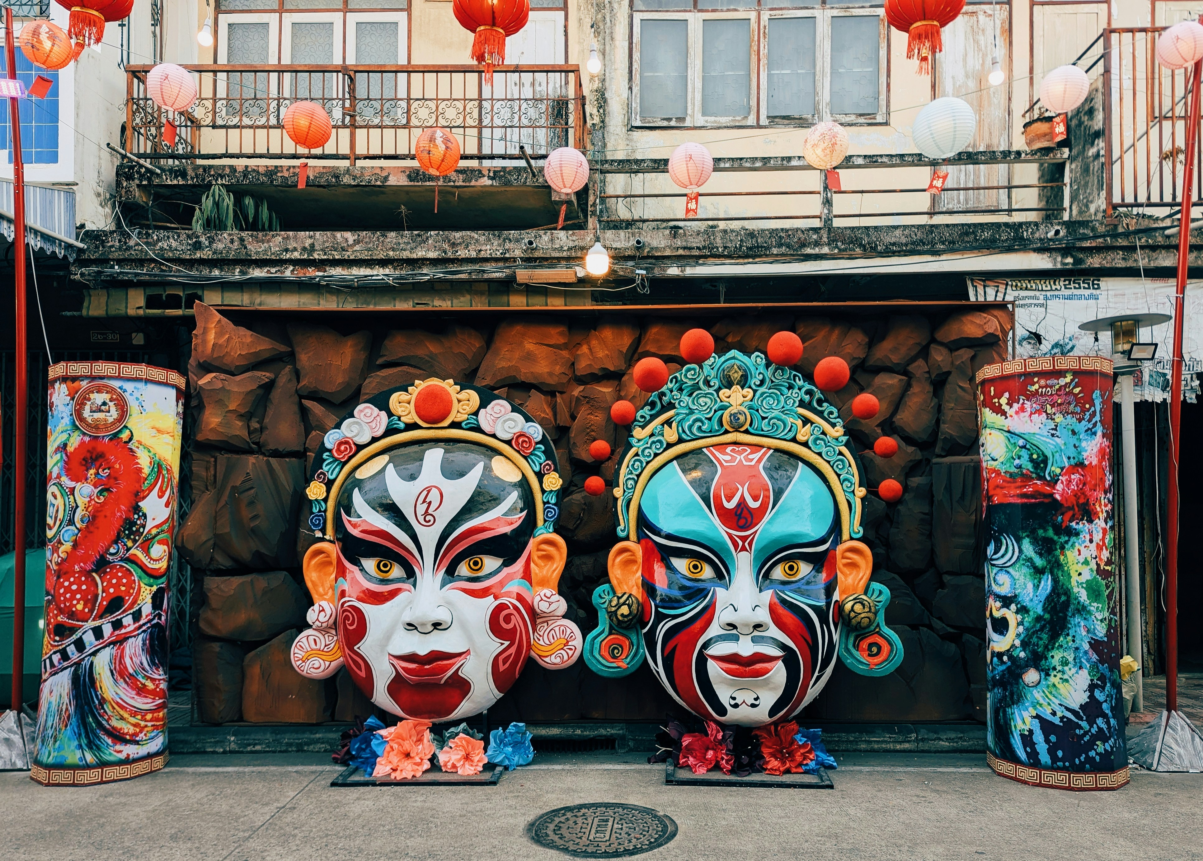 Zwei kunstvolle Masken mit aufwendigem Make-up und Kopfschmuck.