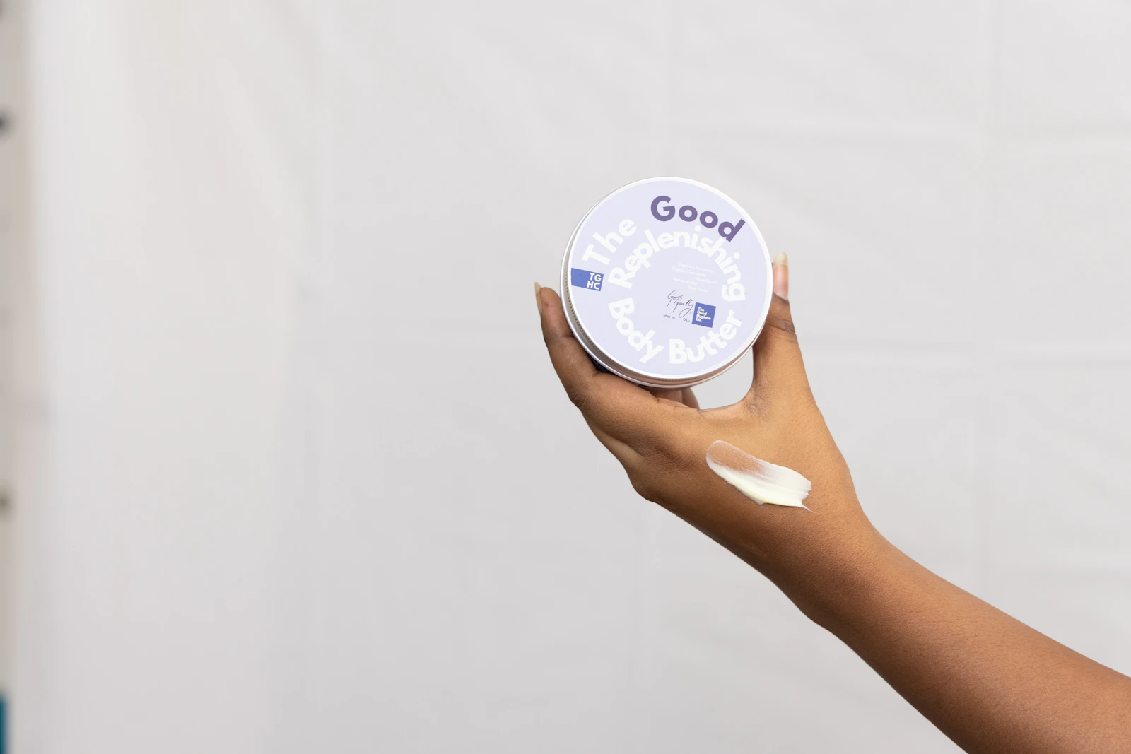 hand holding a jar of moisturising cream
