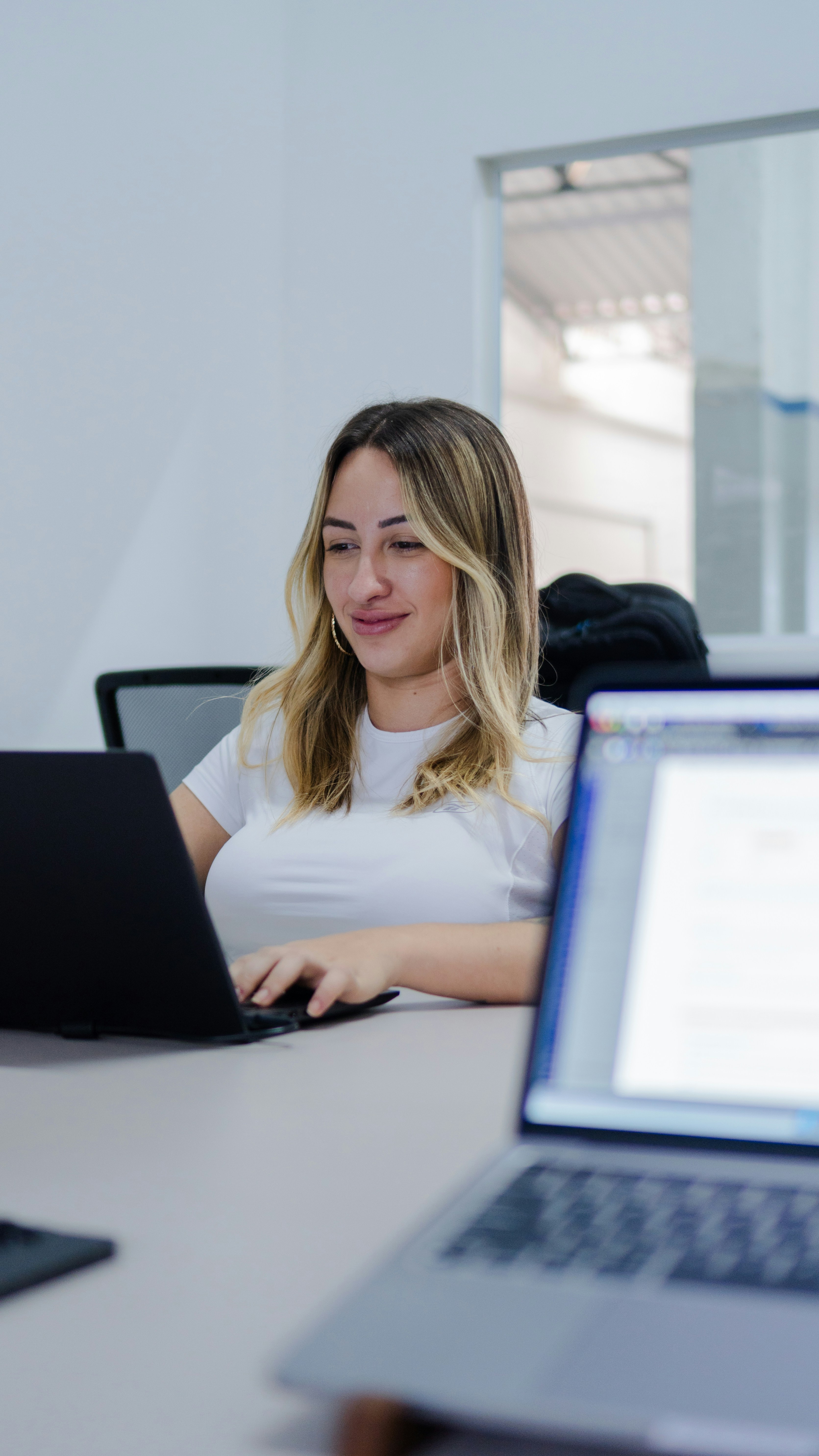 Young woman working on a laptop in an office.