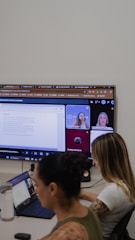 People in a video conference call on a large screen.