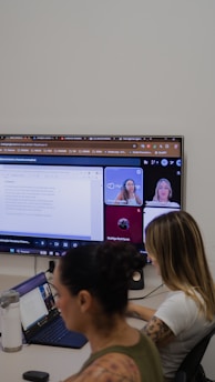 People in a video conference call on a large screen.