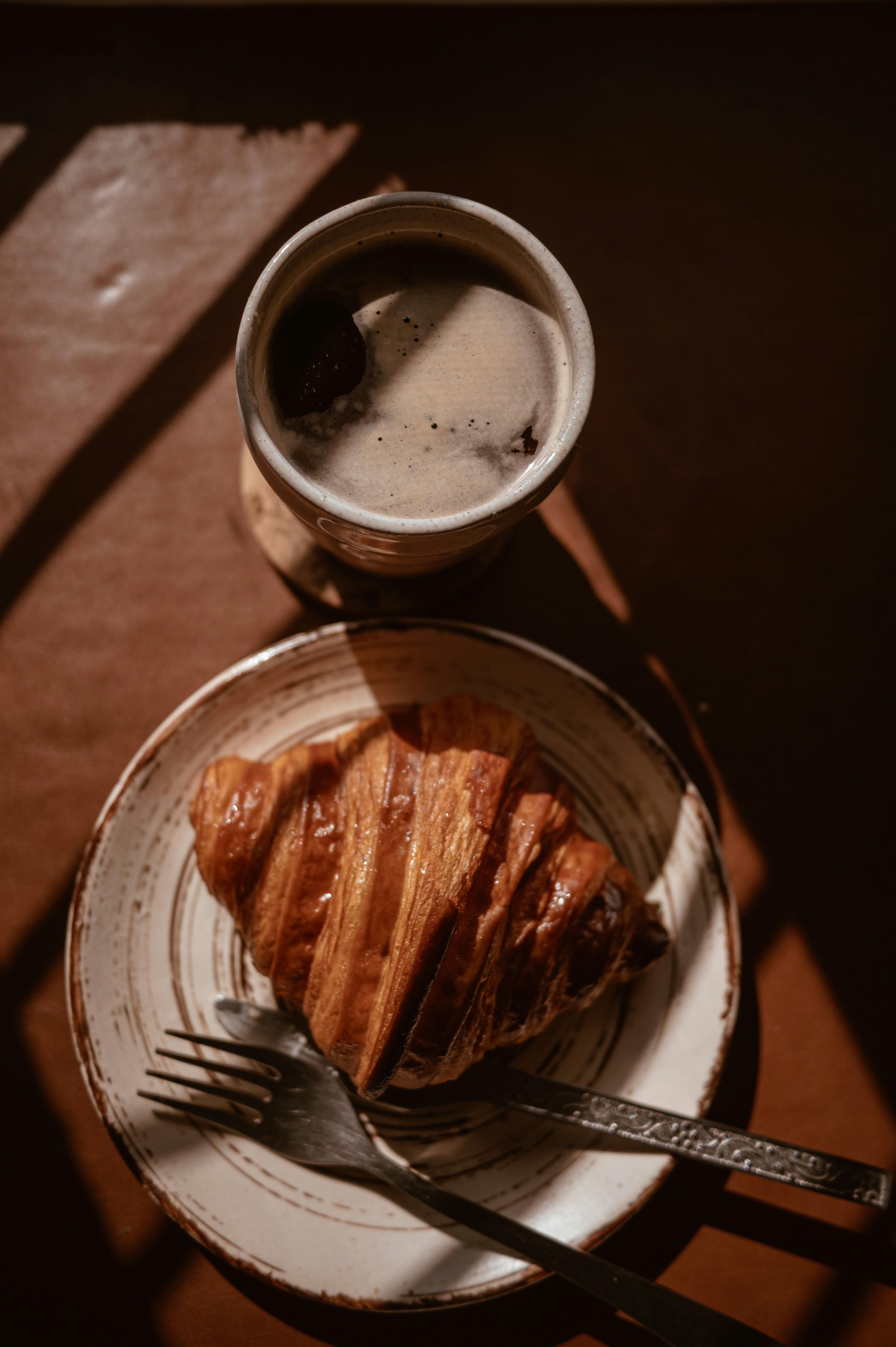 Croissant und Kaffee auf einem rustikalen Tisch