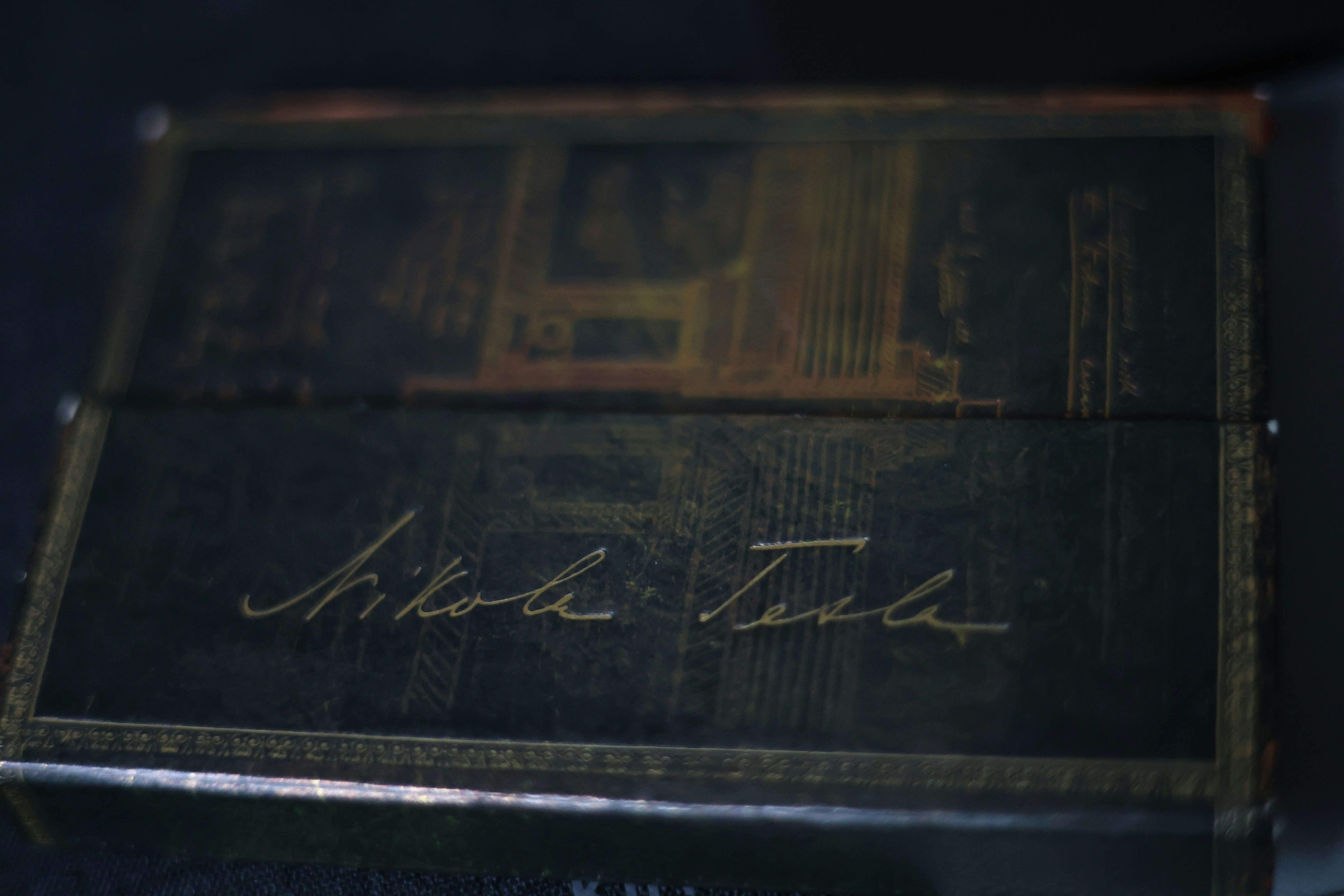 Nikola tesla's signature on a dark, ornate box
