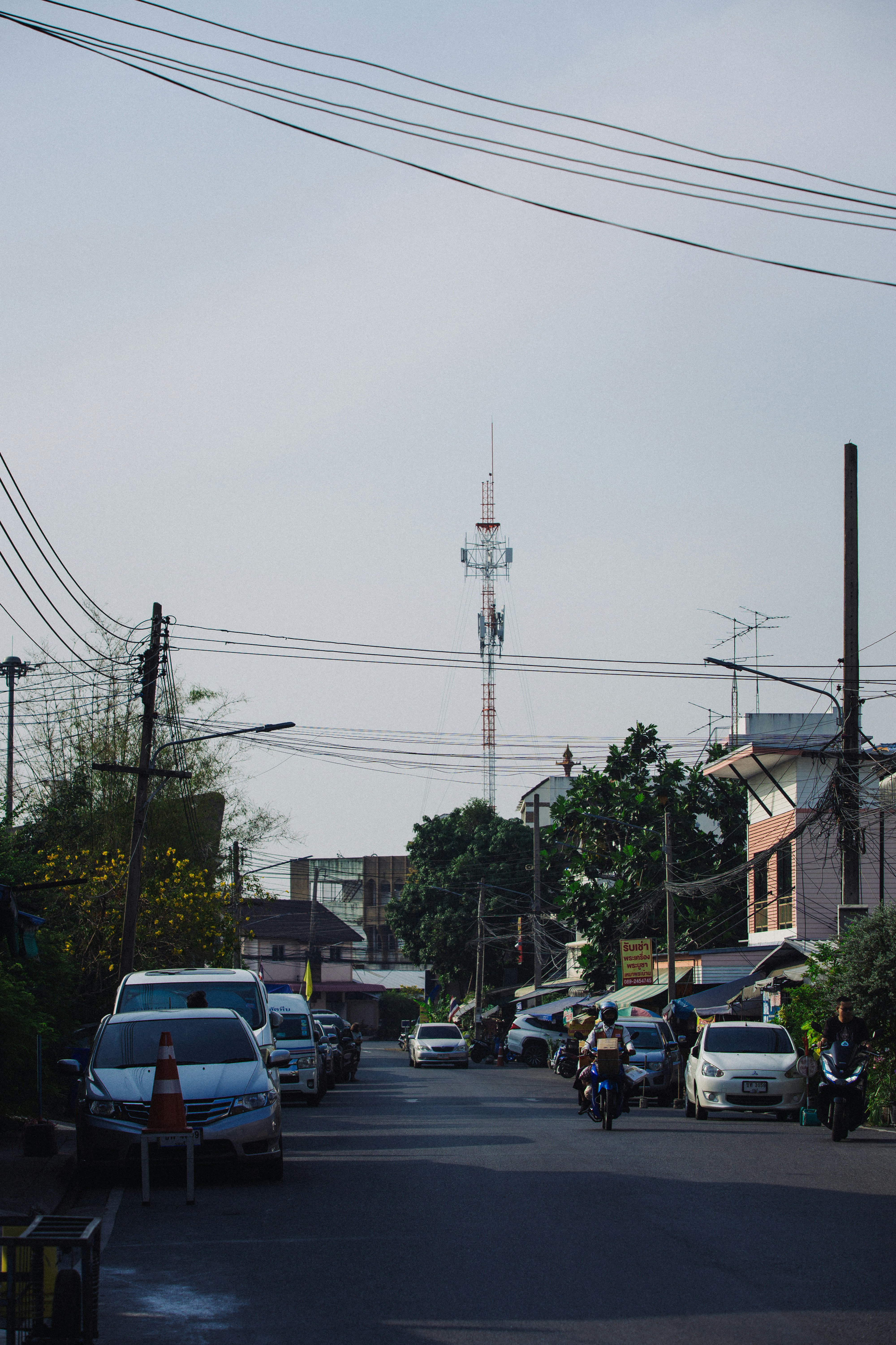 Street scene with cars, buildings, and a distant tower.