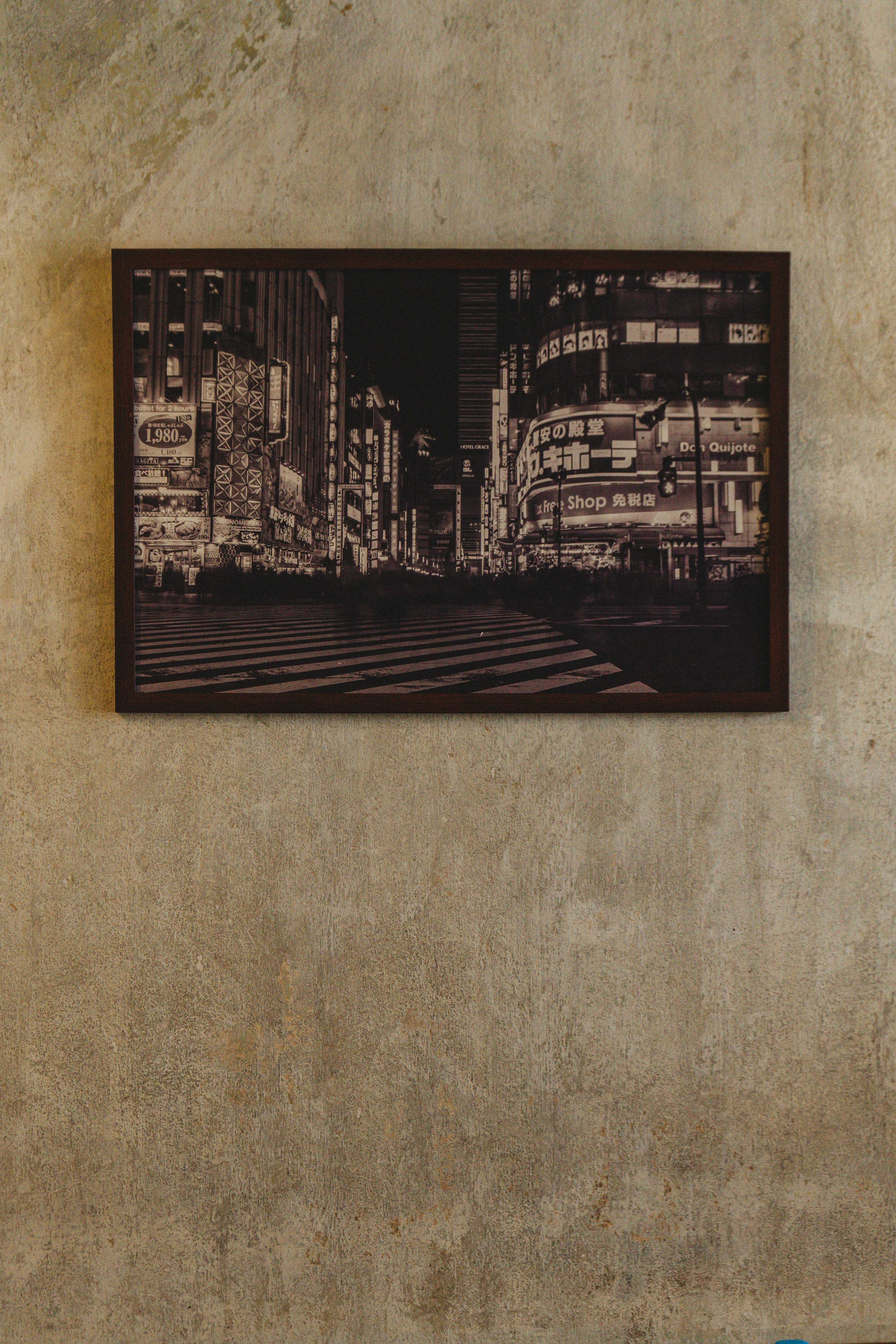 Framed nighttime cityscape with illuminated buildings and crosswalk.