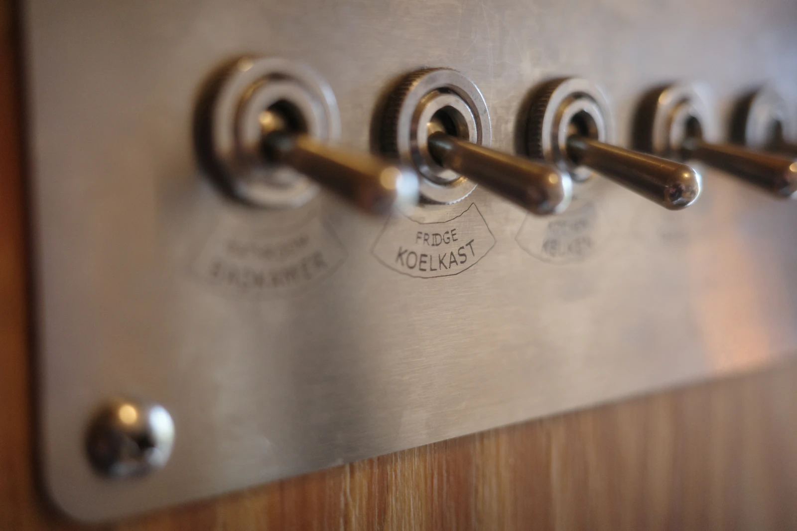 Row of metal toggle light switches on a wall