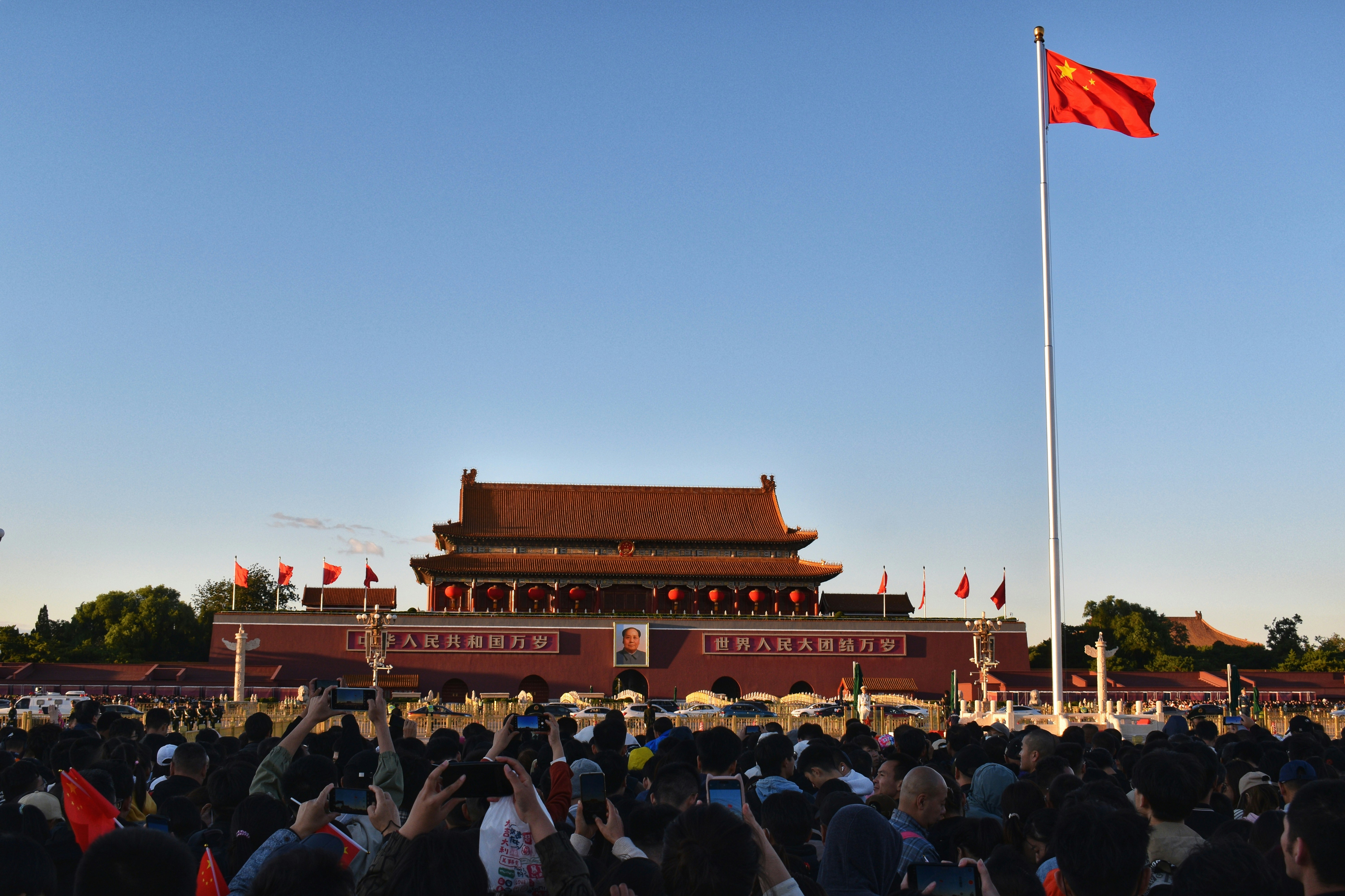 Tiananmen square with chinese flag and crowds