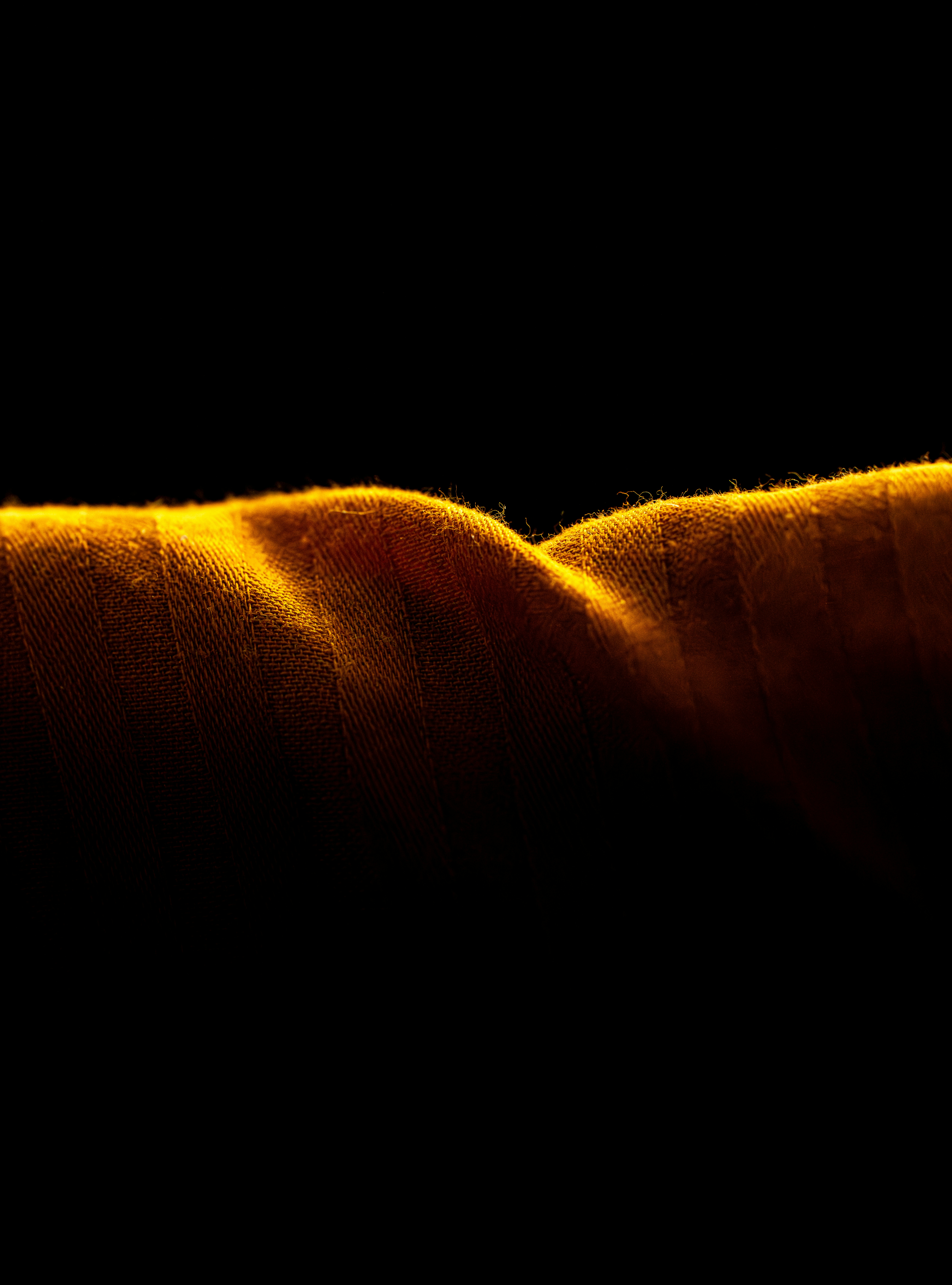 Close-up of textured orange fabric with dramatic lighting