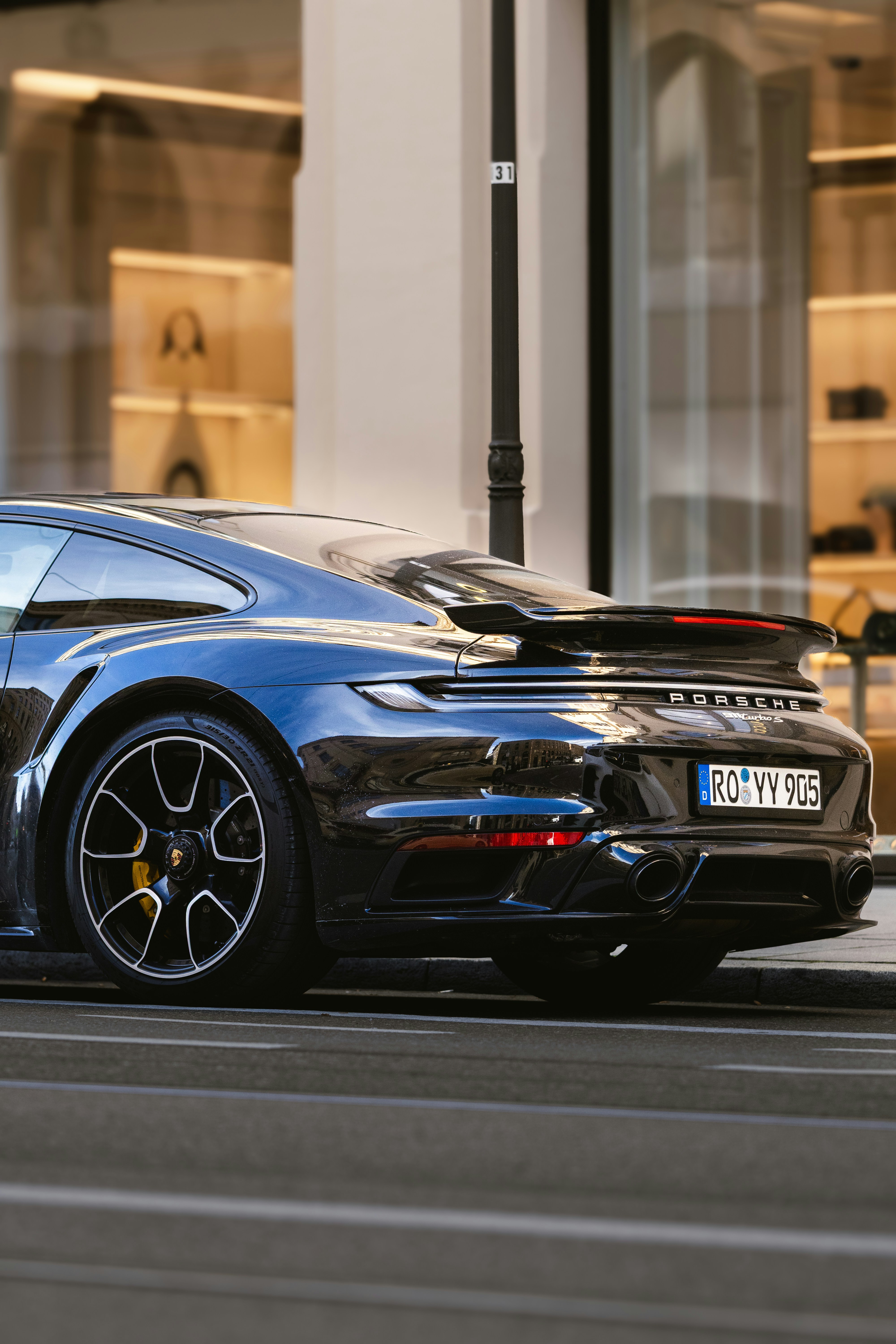 A black porsche 911 turbo s parked on a street.