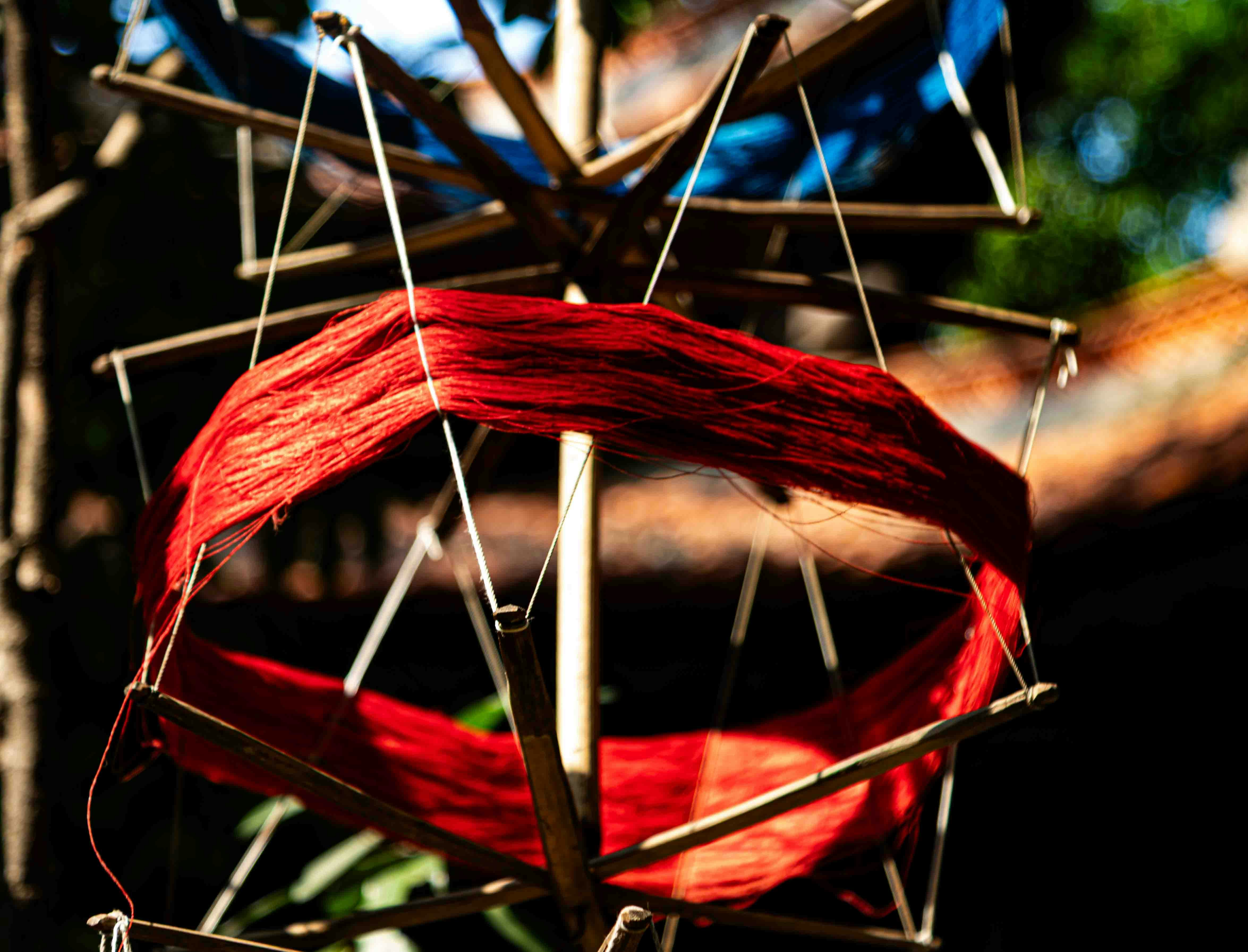 Red yarn wound on a wooden spindle