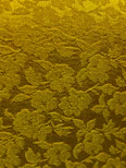 A textured golden fabric with a floral pattern.