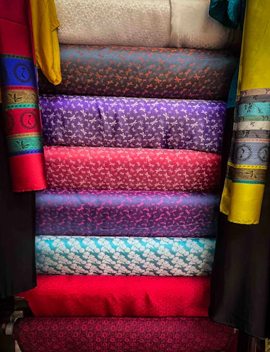 Stack of colorful patterned fabrics in a market
