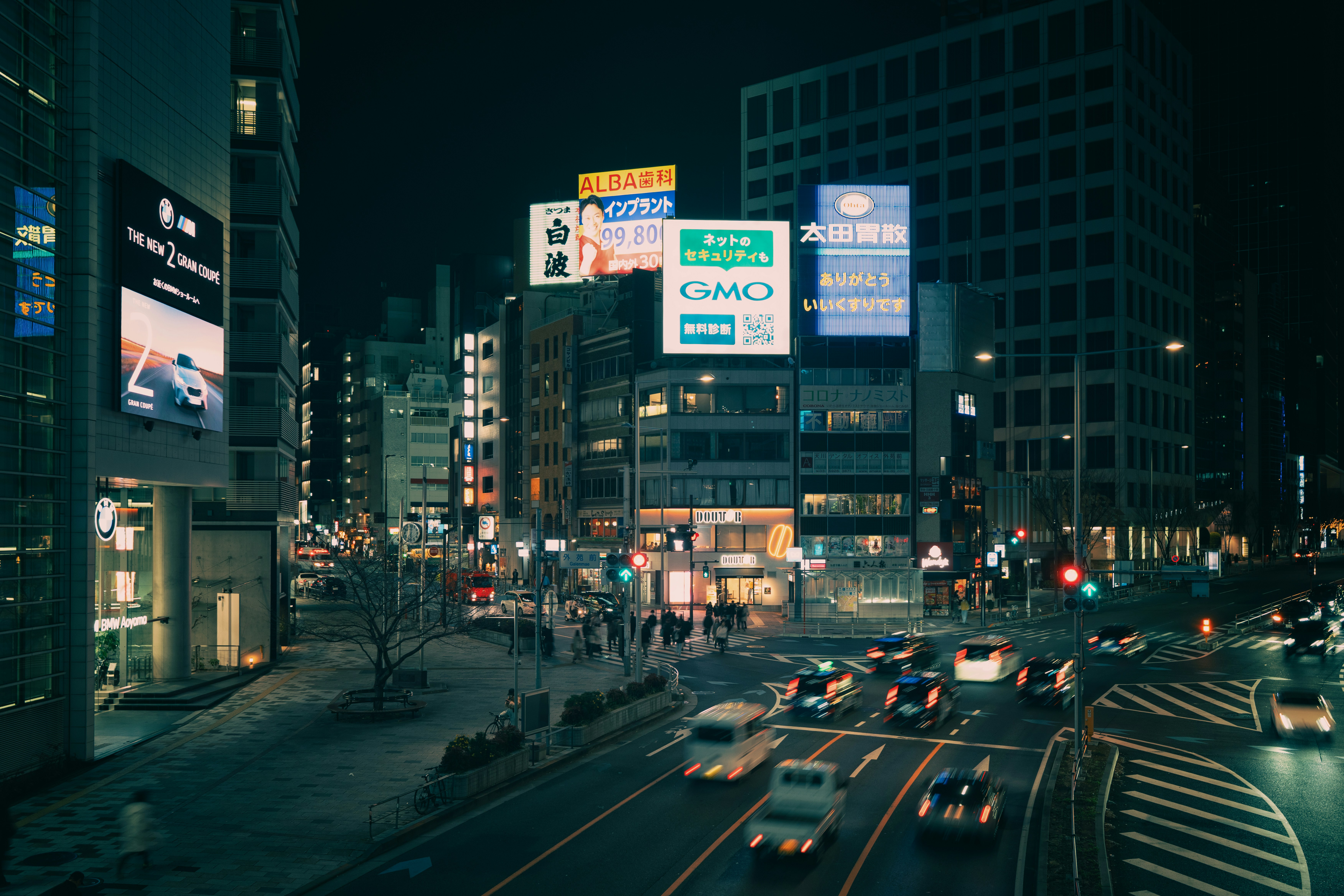 Busy city street at night with glowing billboards