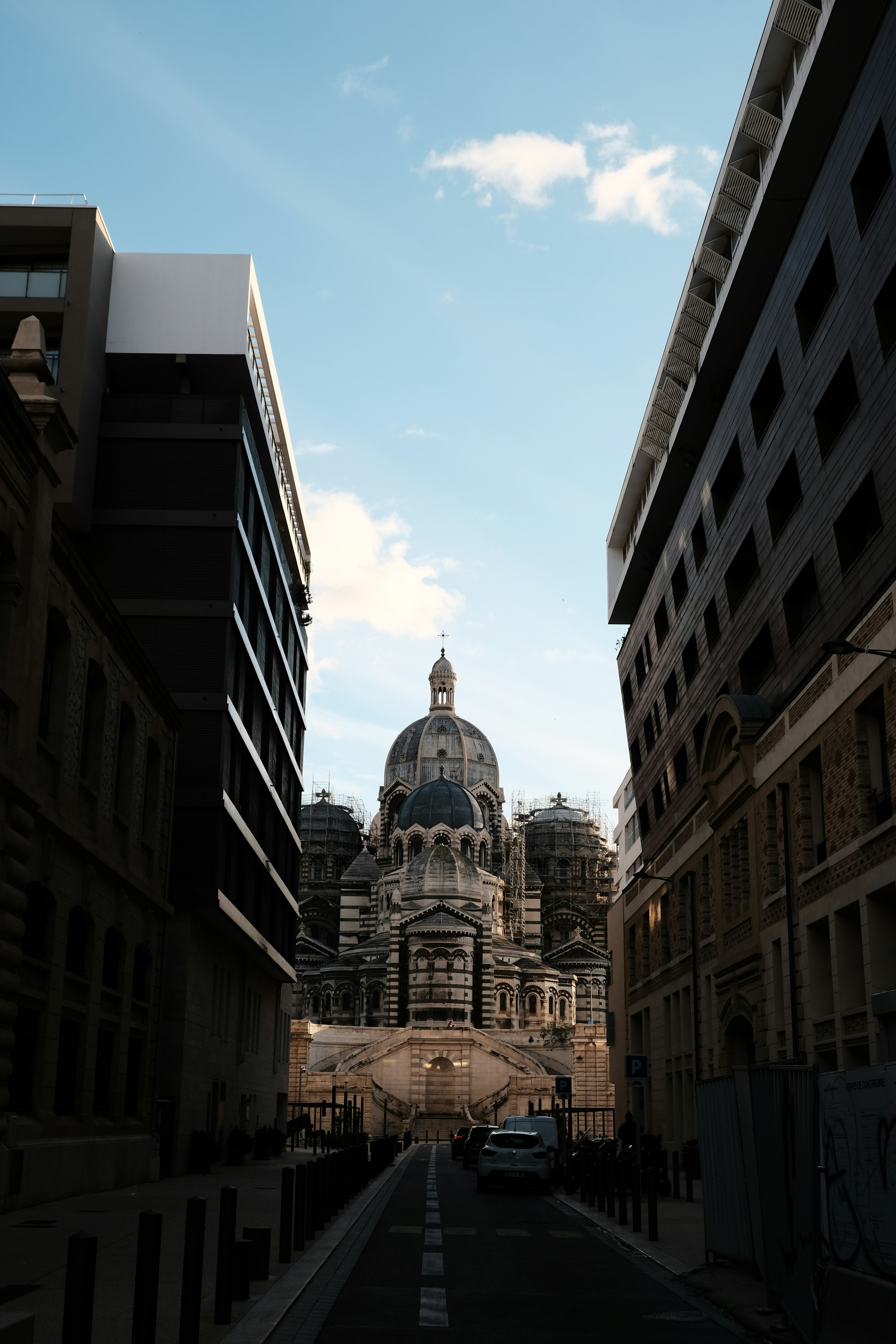 Grande catedral vista entre edifícios modernos sob o céu
