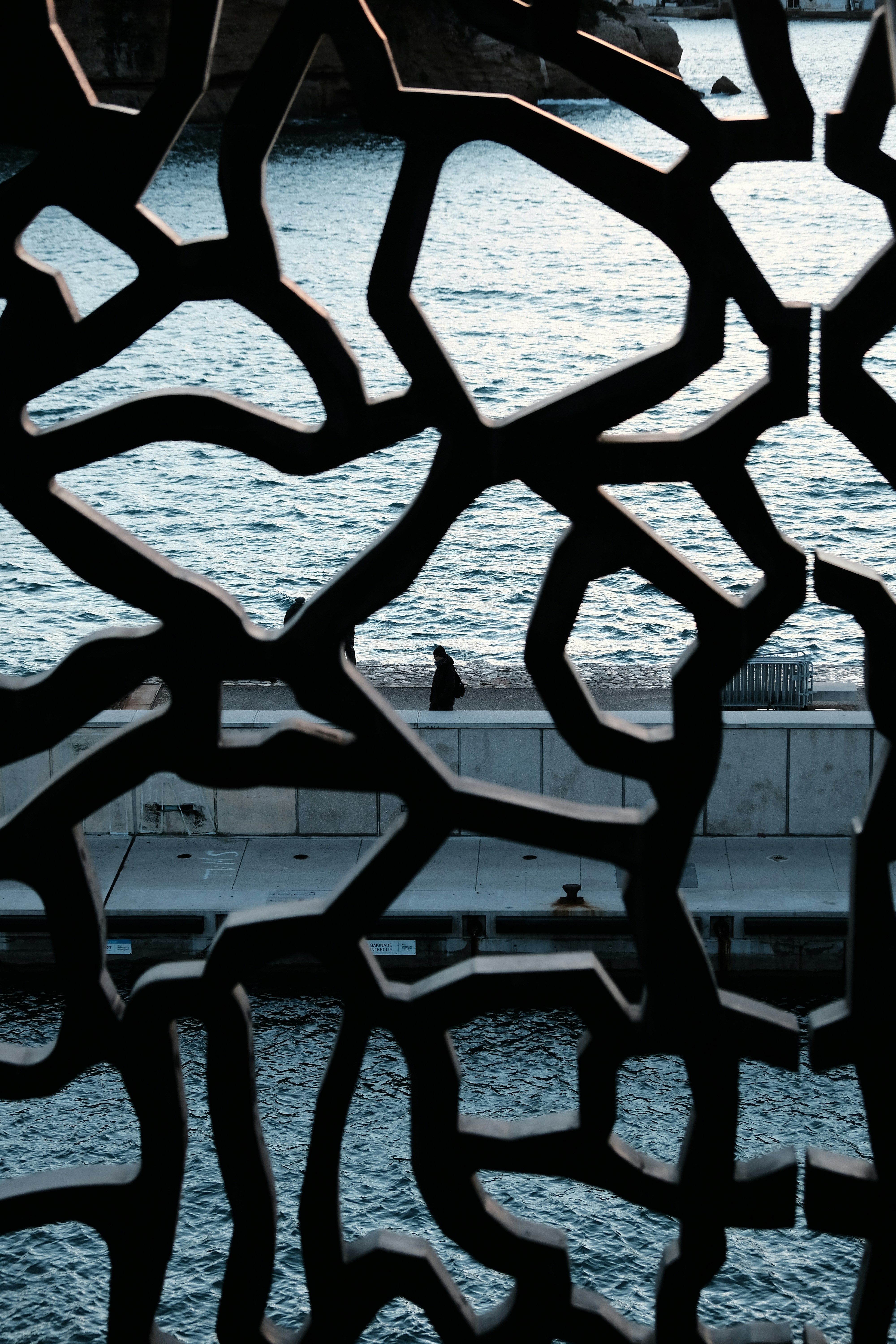 Um padrão escuro abstrato sobrepõe uma vista tranquila do oceano.