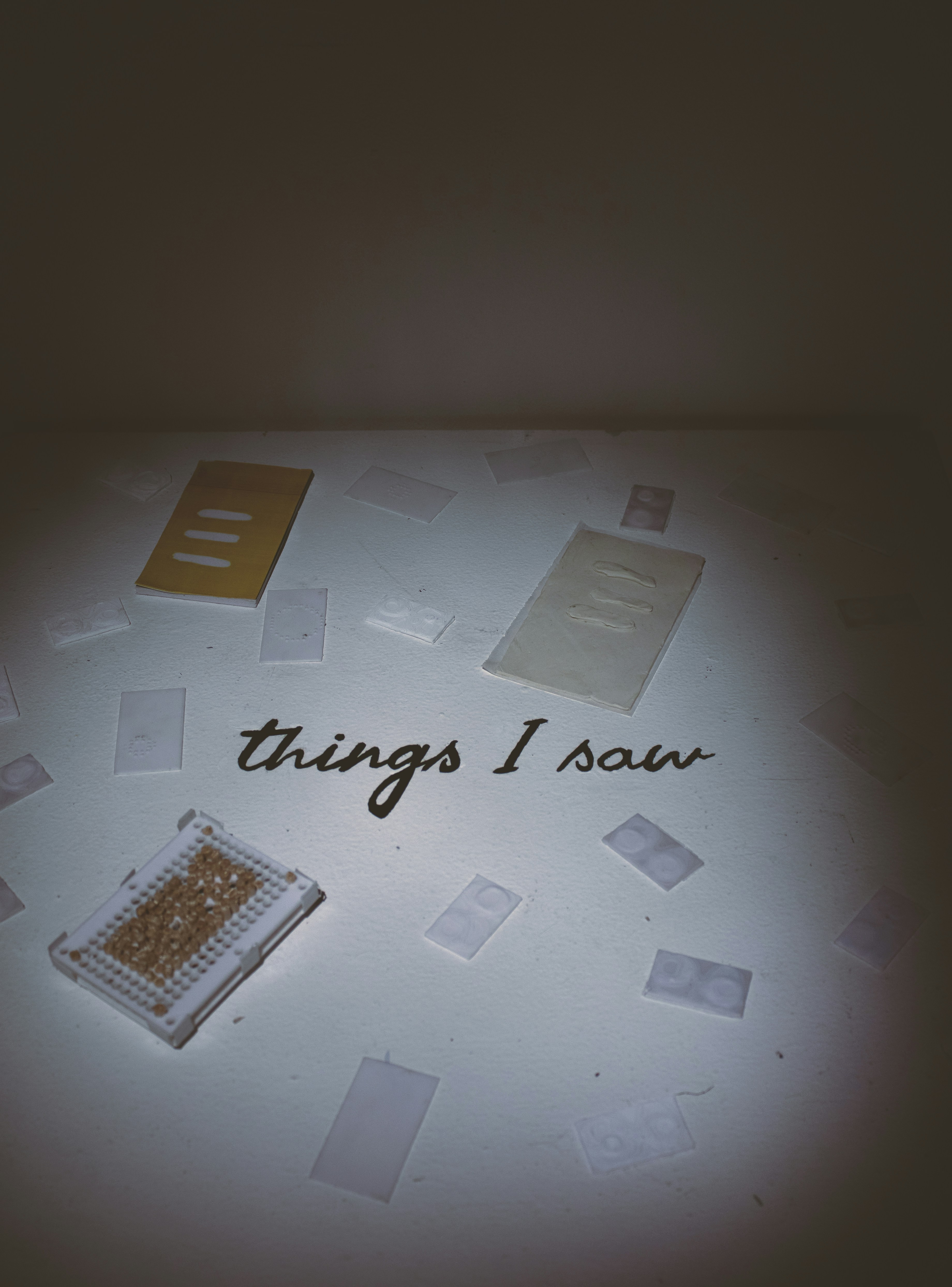 Several small books and papers scattered on a white surface.