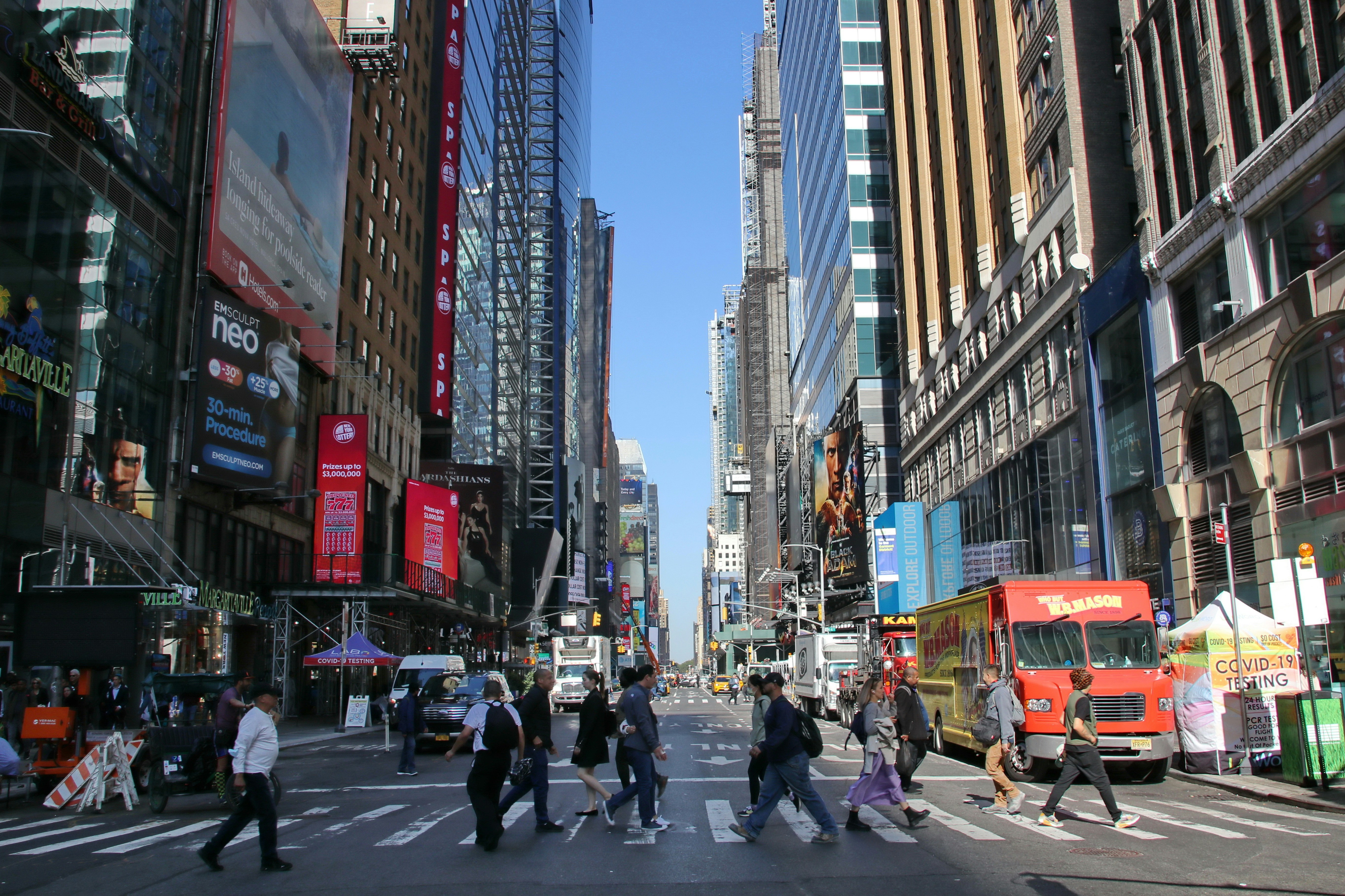 People crossing a busy street in a city