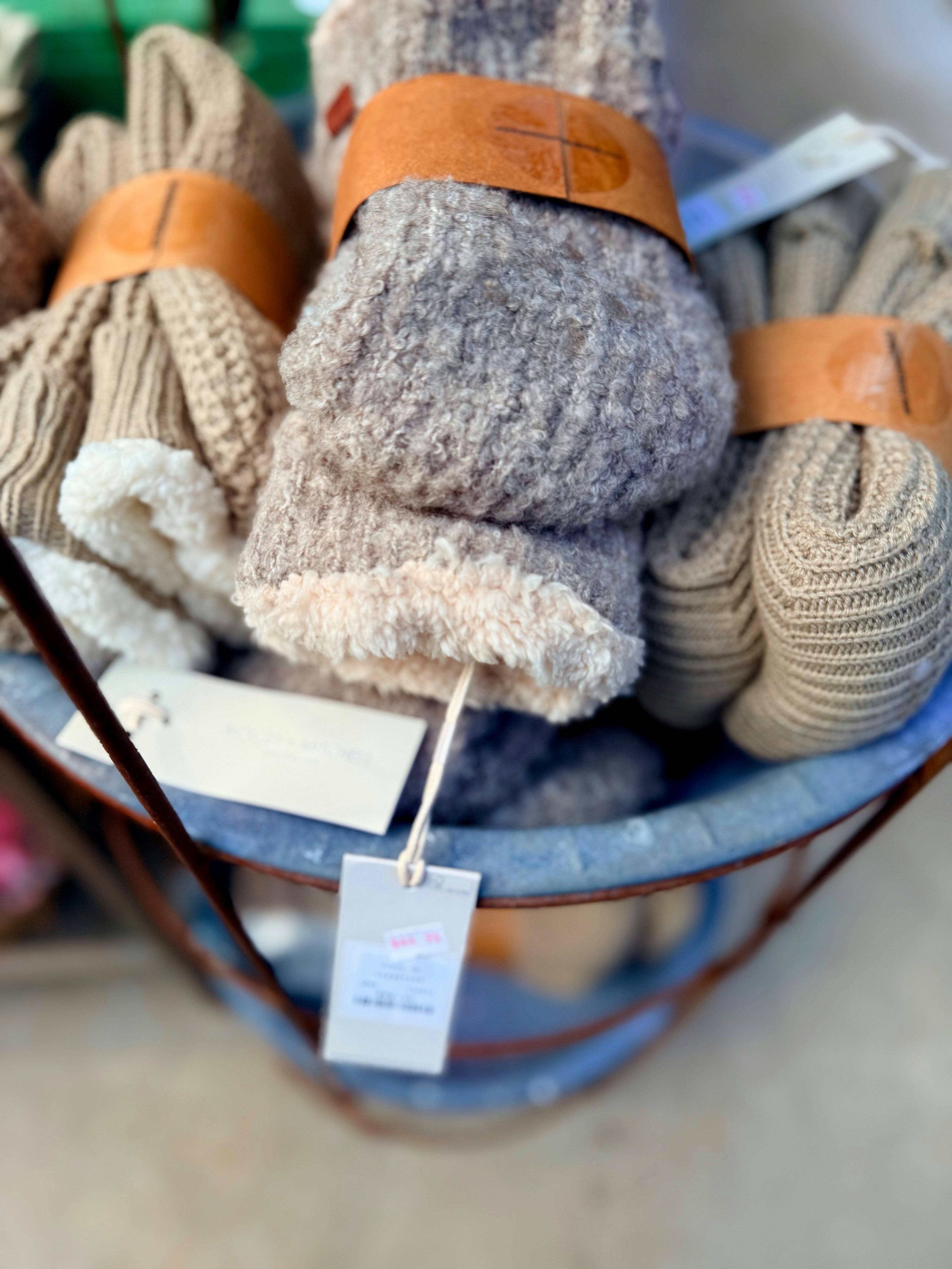 Cozy knitted gloves with sherpa lining in a basket.
