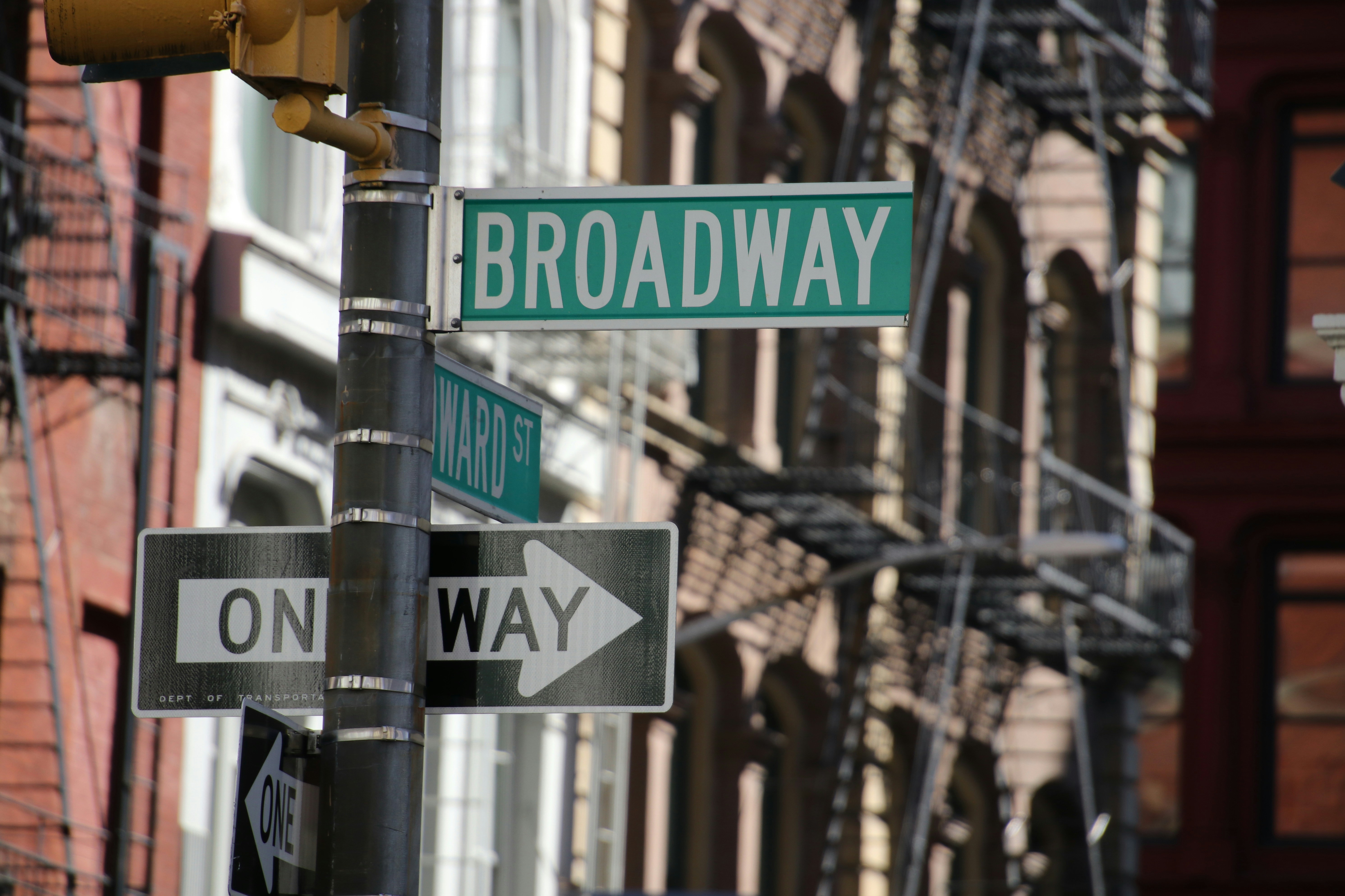 Broadway street sign with one way arrow.