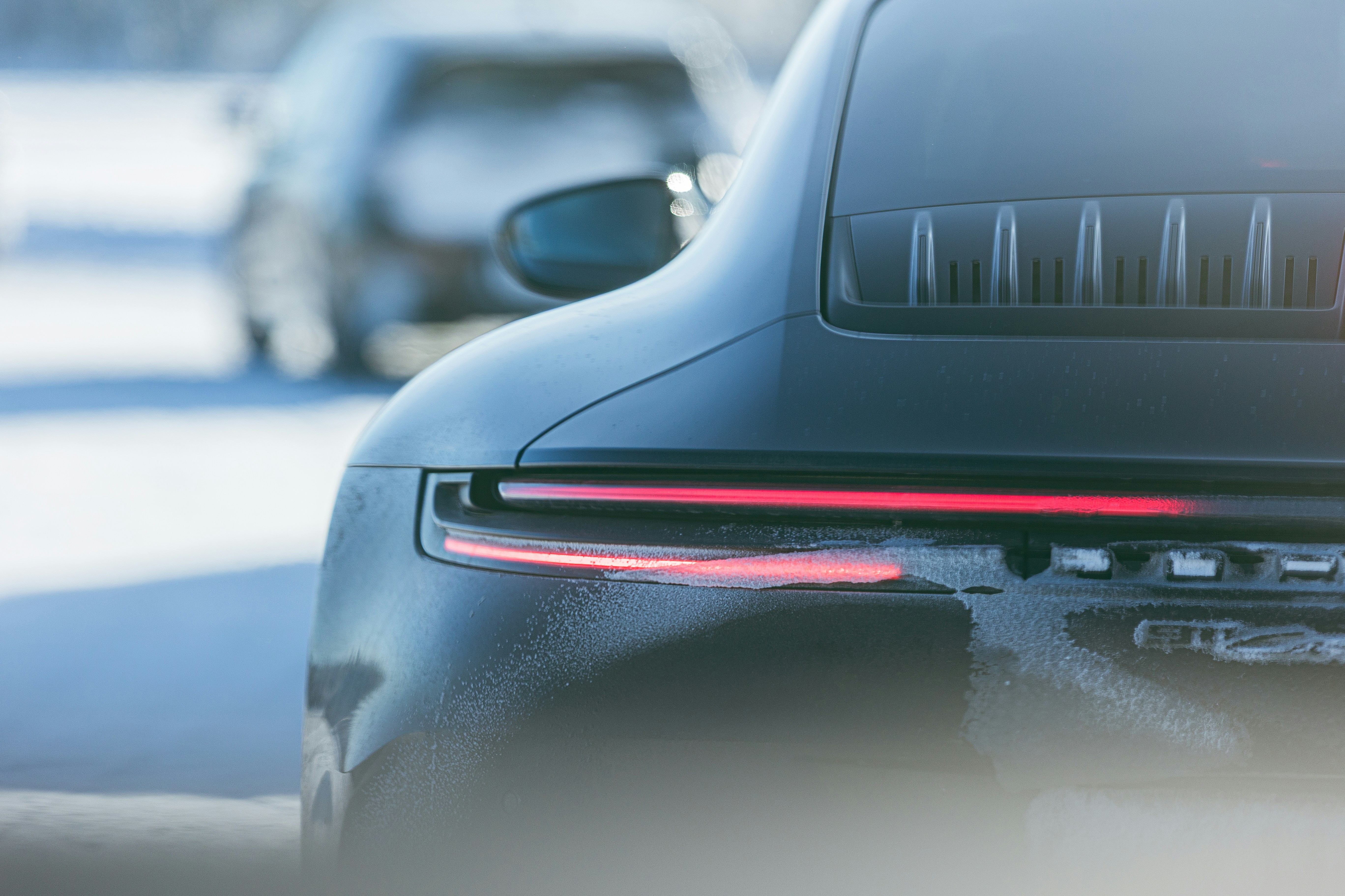 Rear view of a black car with illuminated taillights