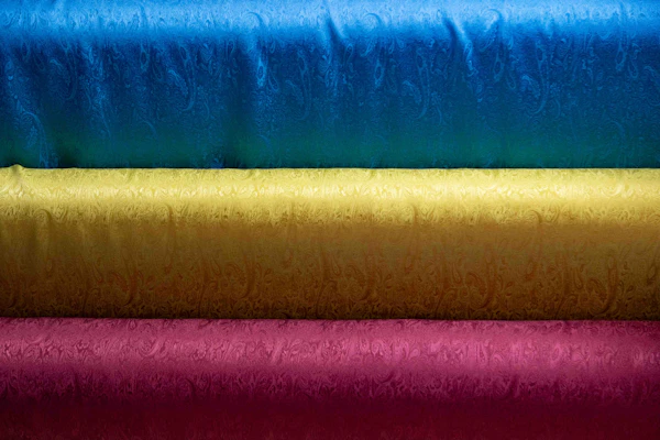 Colourful folded sarong and fabric rolls