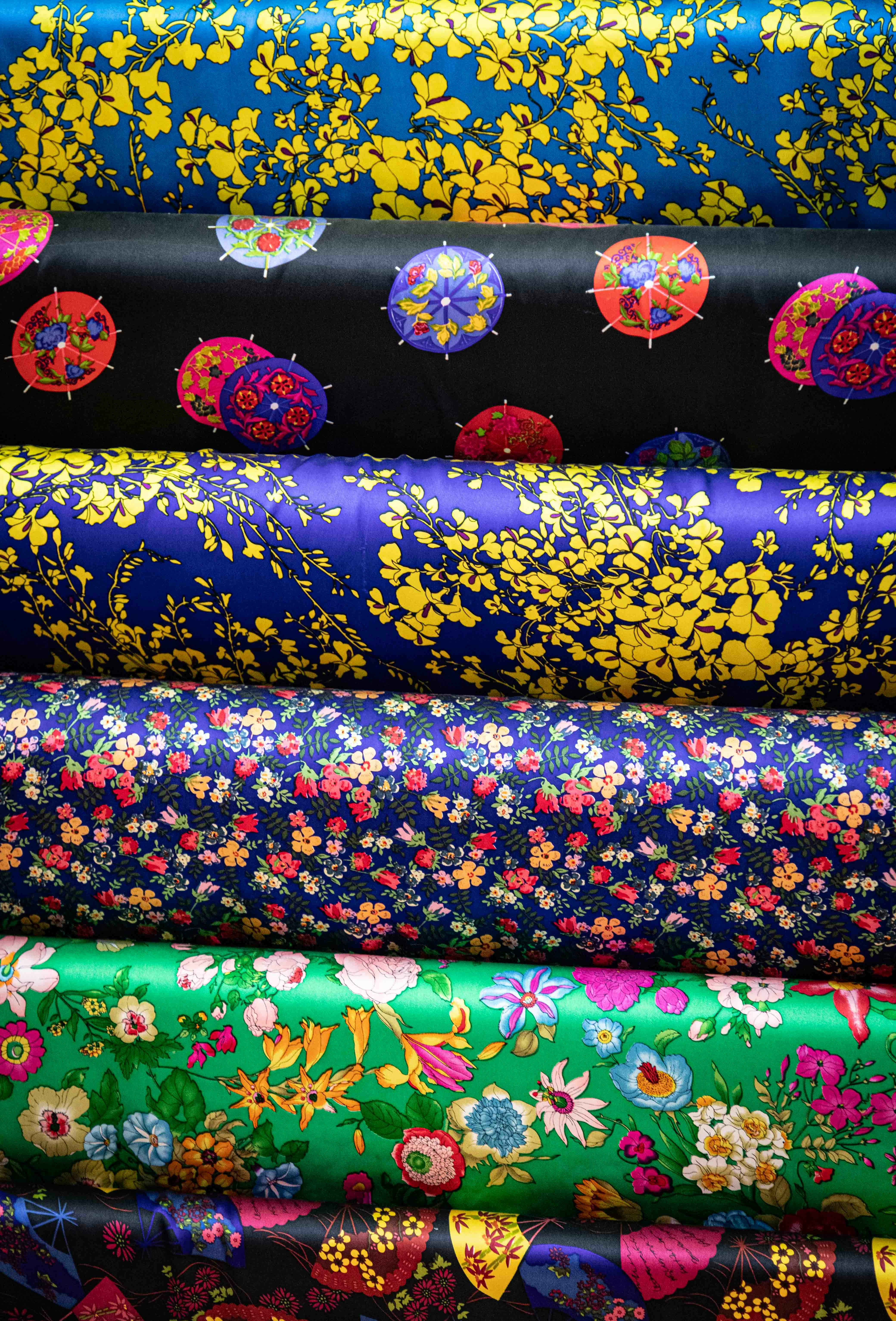 Stack of colorful patterned fabrics with floral designs.