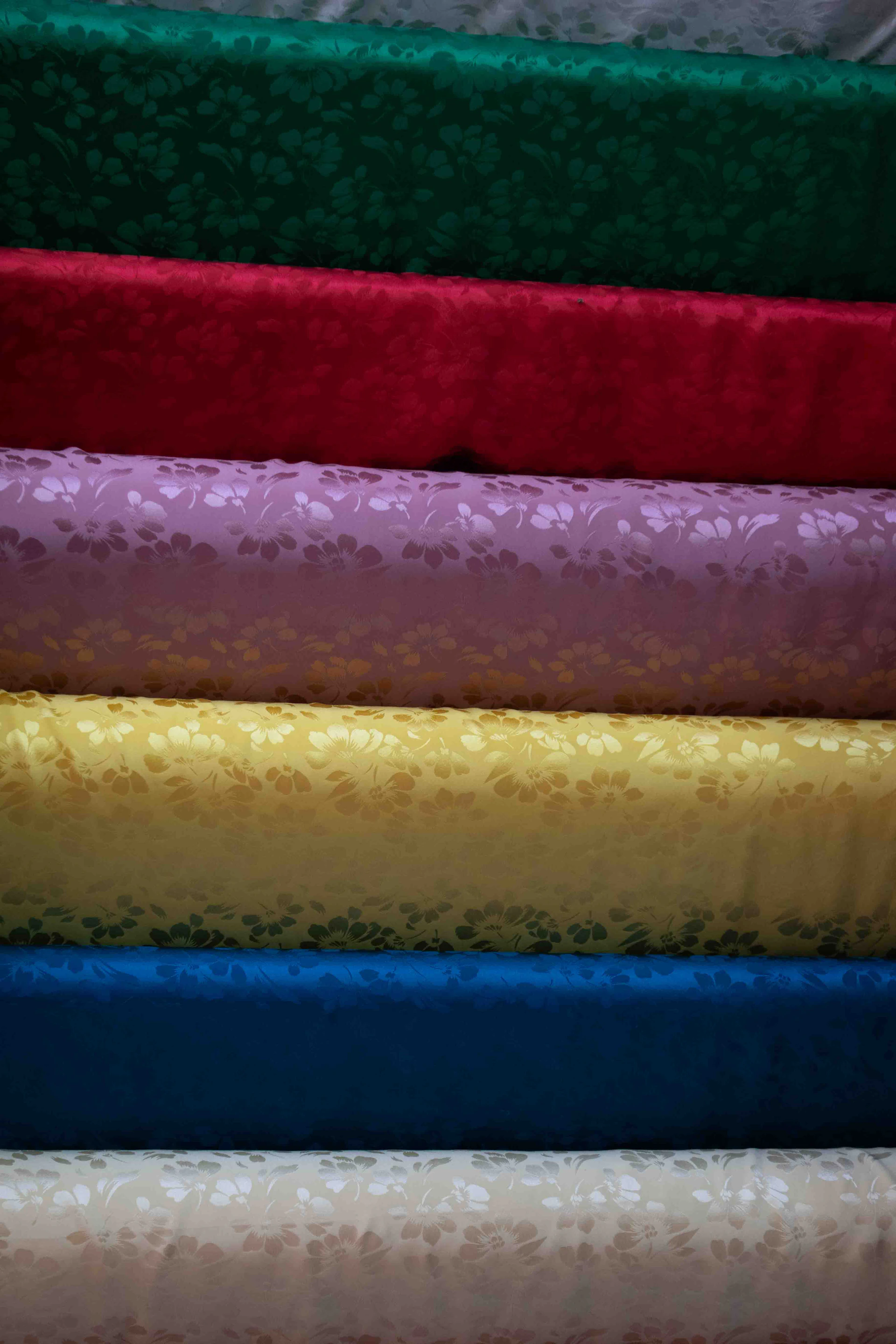 Stack of colorful patterned fabric rolls