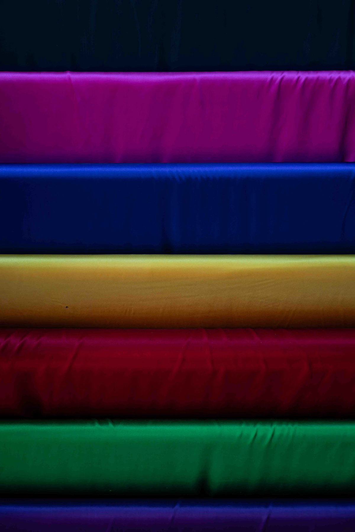 Stacked rolls of colorful fabric